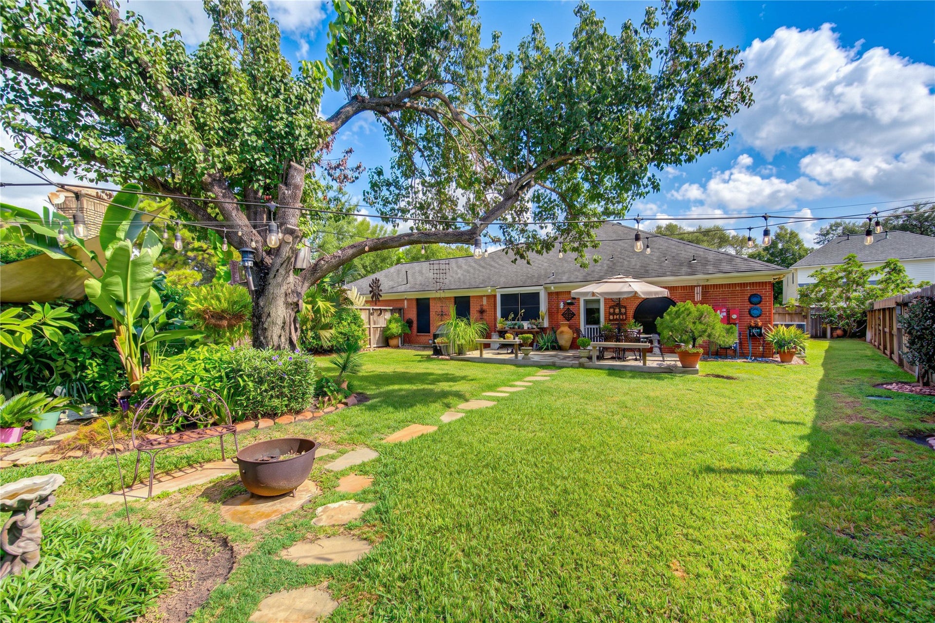 6839 Hertford Park Drive, Houston, TX 77084 Mature trees, garden beds and a stepping-stone path create a peaceful backyard retreat.