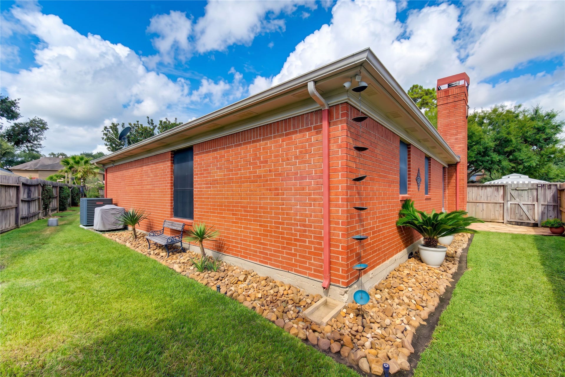 6839 Hertford Park Drive, Houston, TX 77084 Neatly maintained landscaping continues along the homes brick exterior.