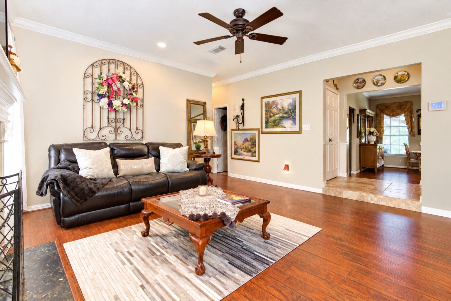 6839 Hertford Park Drive, Houston, TX 77084 Warm wood-look flooring and crown molding give the living room an inviting feel.