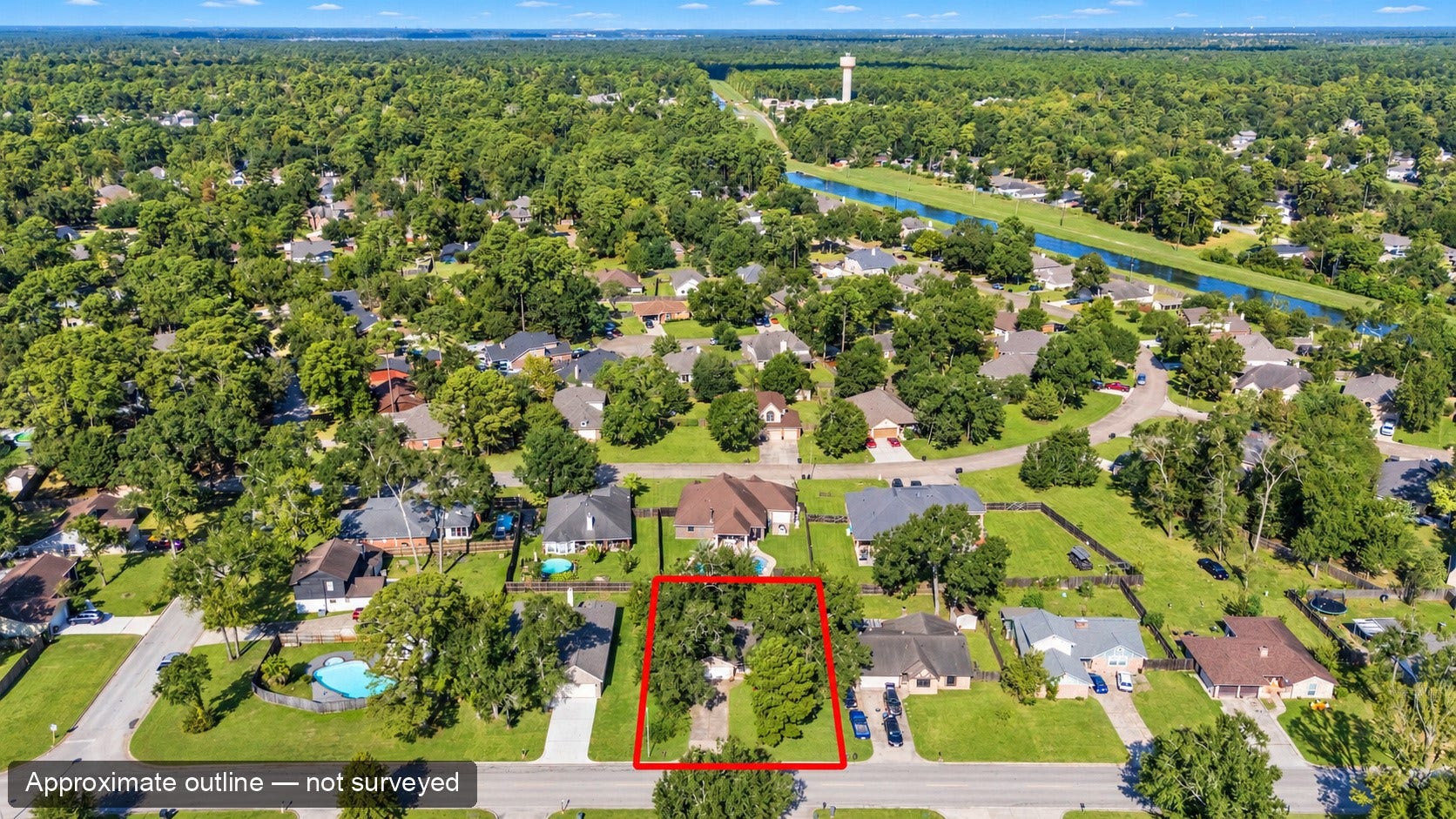 Aerial perspective of the home within the surrounding neighborhood. The red outline is approximate, for location only, and is not a surveyed boundary.