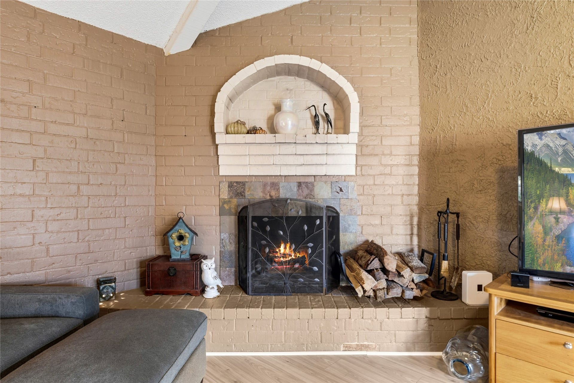 Fireplace detail with a brick hearth and an arched display niche above.