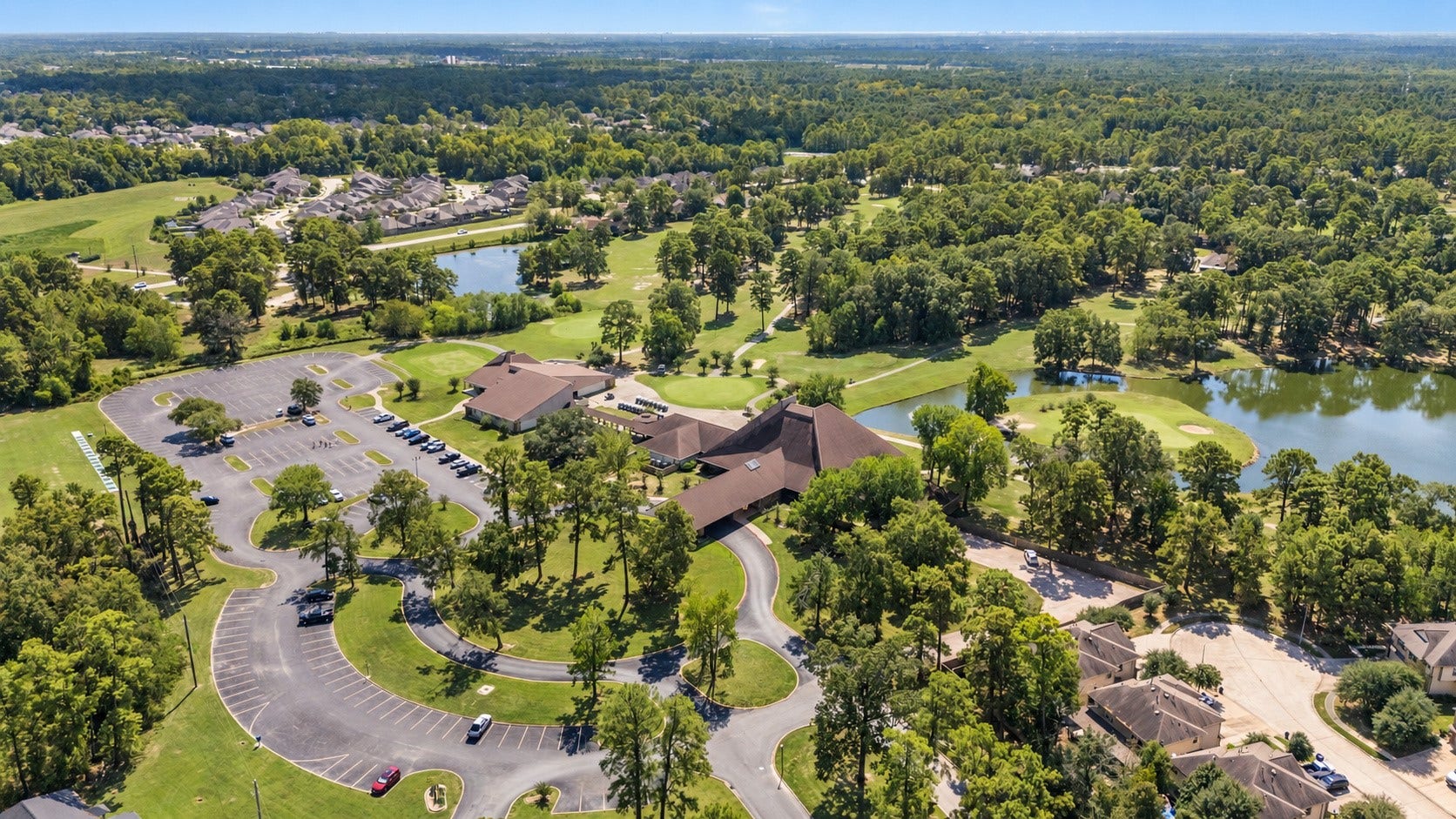 Aerial view of the Newport clubhouse area, surrounding water, and mature trees.