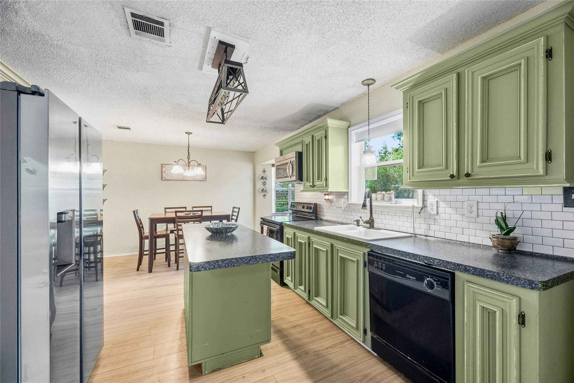 The kitchen island provides an additional preparation surface beside the breakfast area and its bay window.