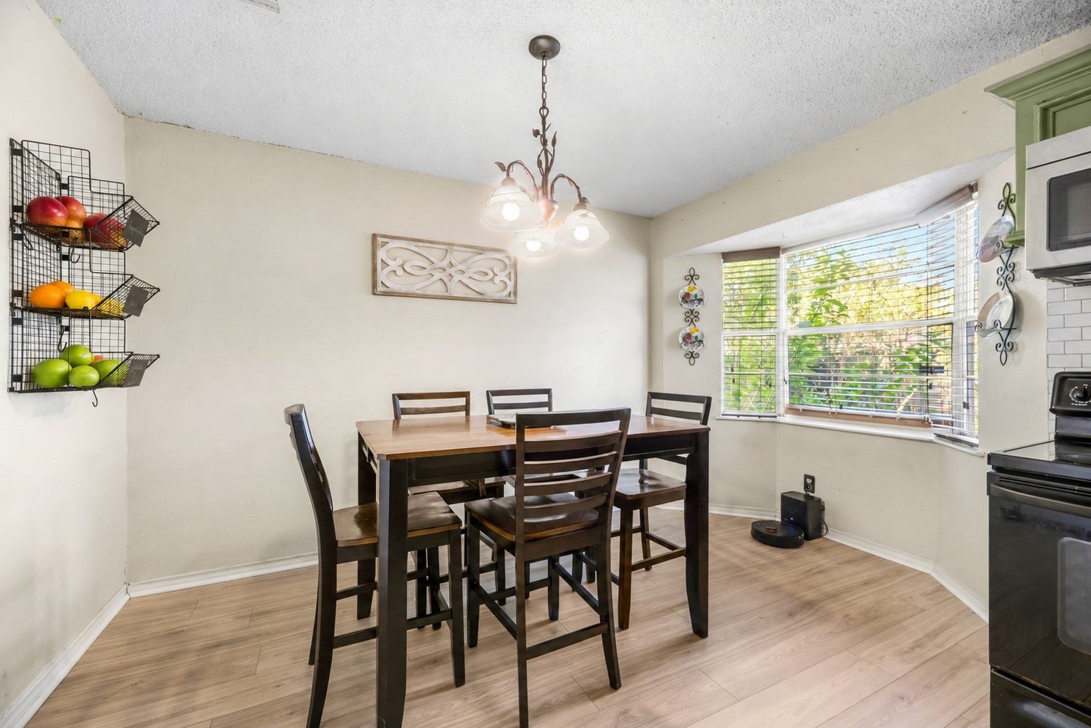 Breakfast area beside a bay window, with space for a dining table near the kitchen. Fruit in the wall baskets has been digitally added.
