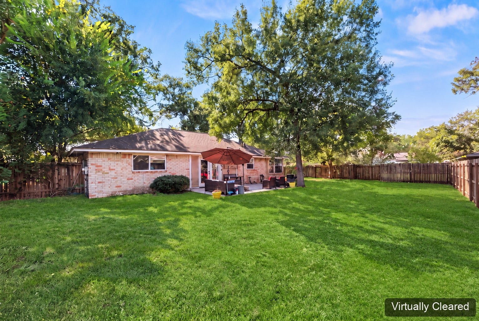 Virtually cleared backyard view toward the home and patio, framed by mature trees. The original photo at the end shows existing yard features.