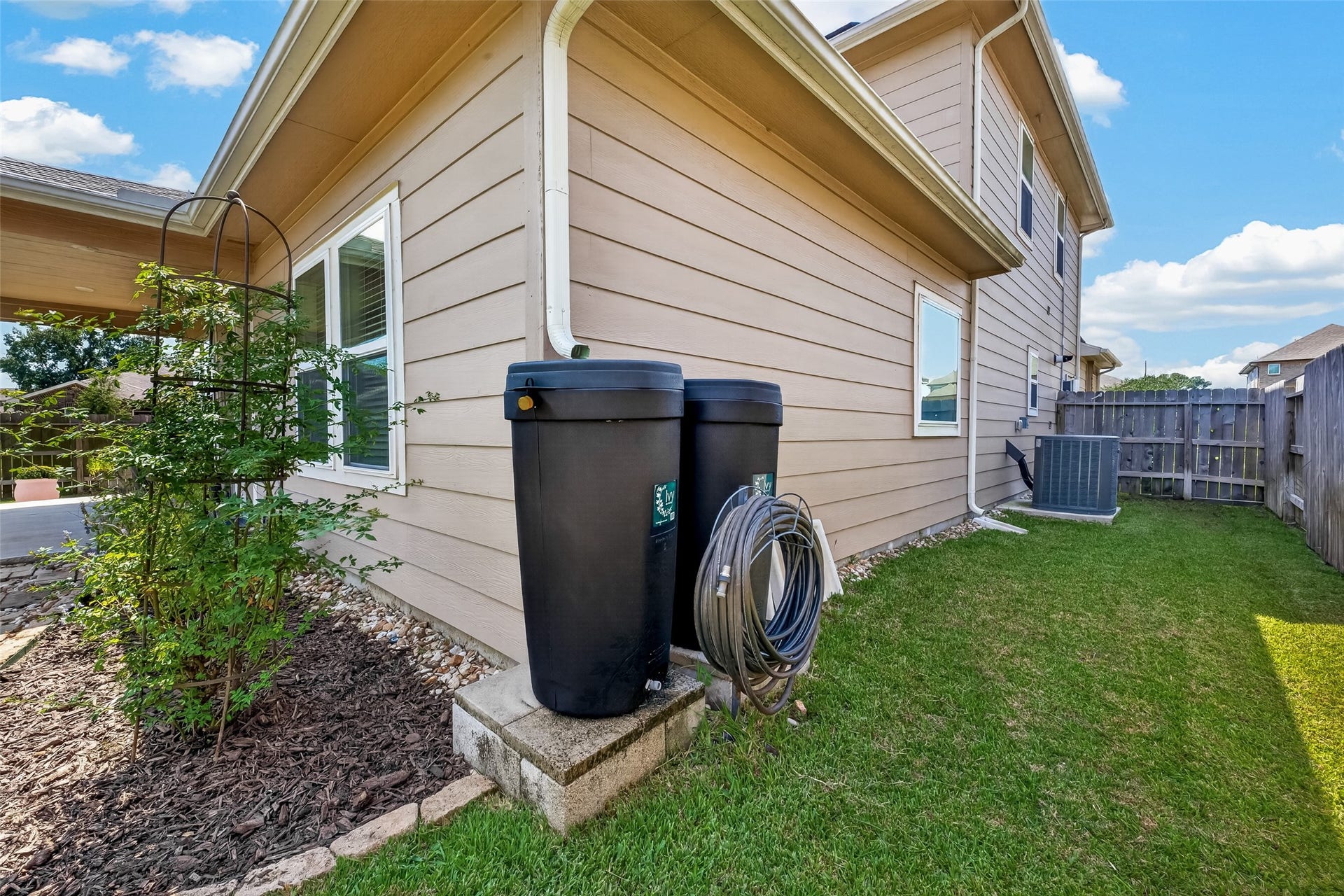 2321 W Winding Pines Drive, Tomball, TX 77375 Three large rain collection barrels store water for water garden and landscaping.