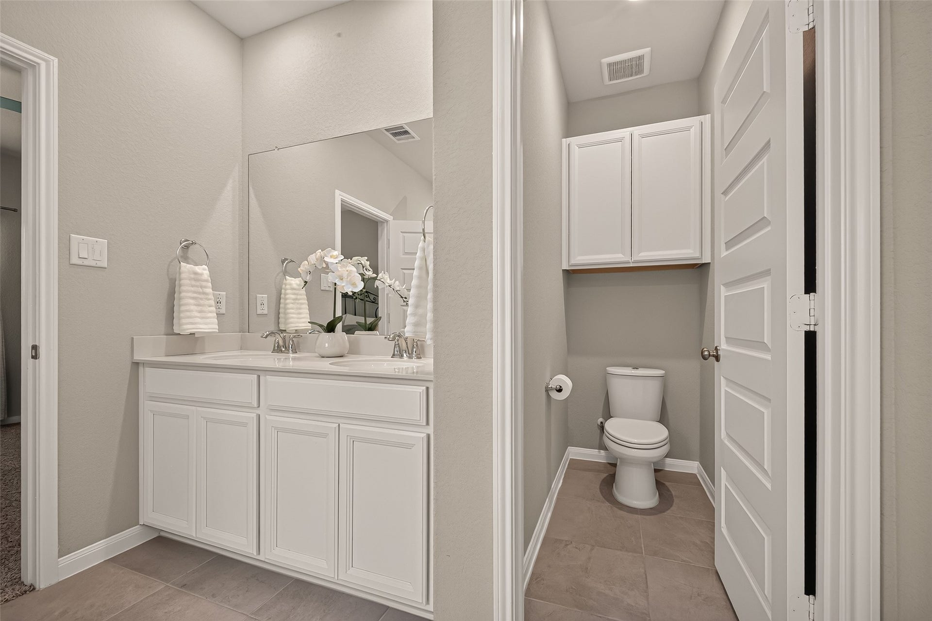 2321 W Winding Pines Drive, Tomball, TX 77375 Large counter with double sinks and an added cabinet above the toilet for storage meets all your needs.