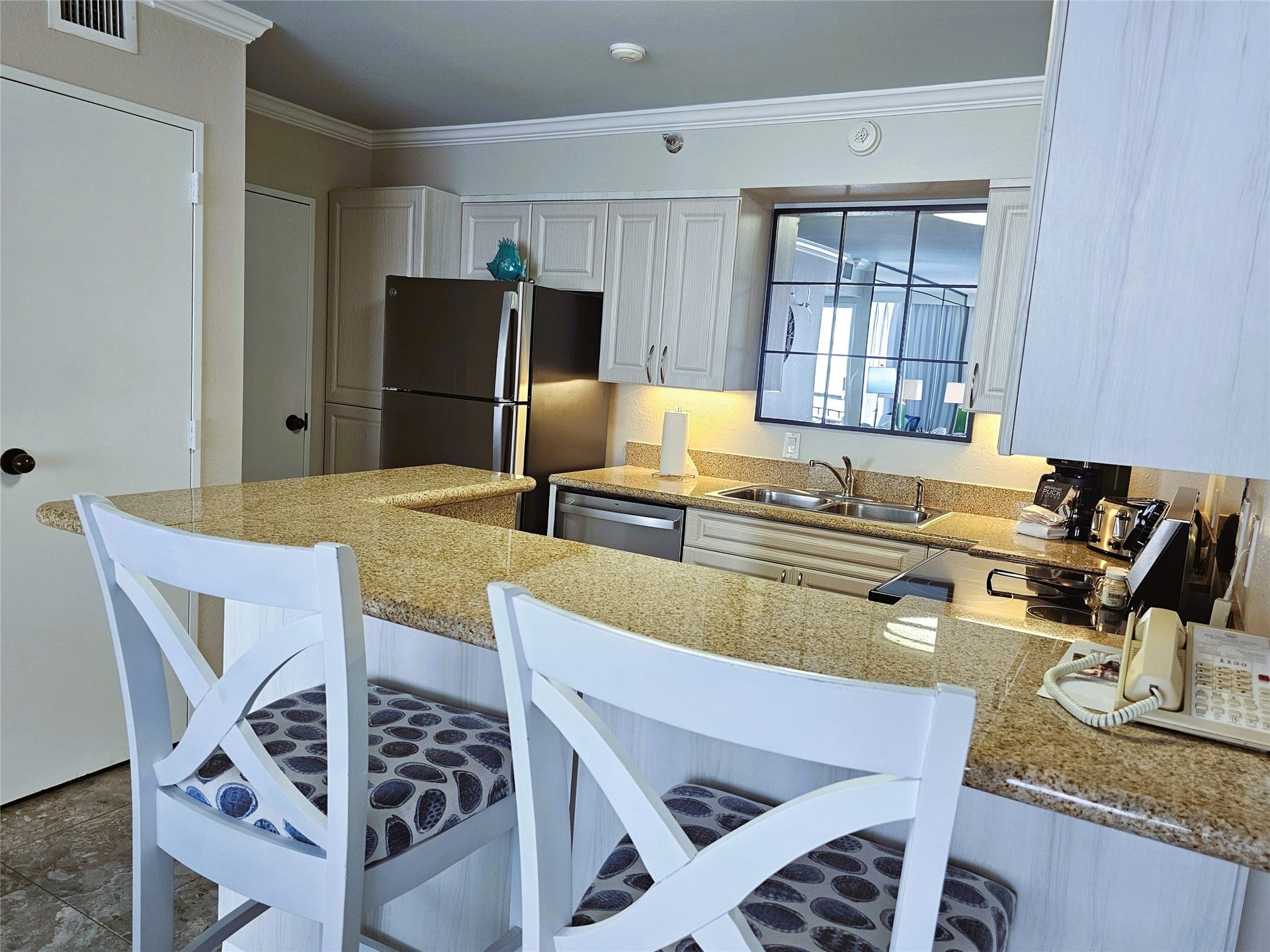 Charming kitchen with granite countertops, modern stainless steel appliances, and ample cabinetry, complemented by a cozy breakfast bar with stylish seating.