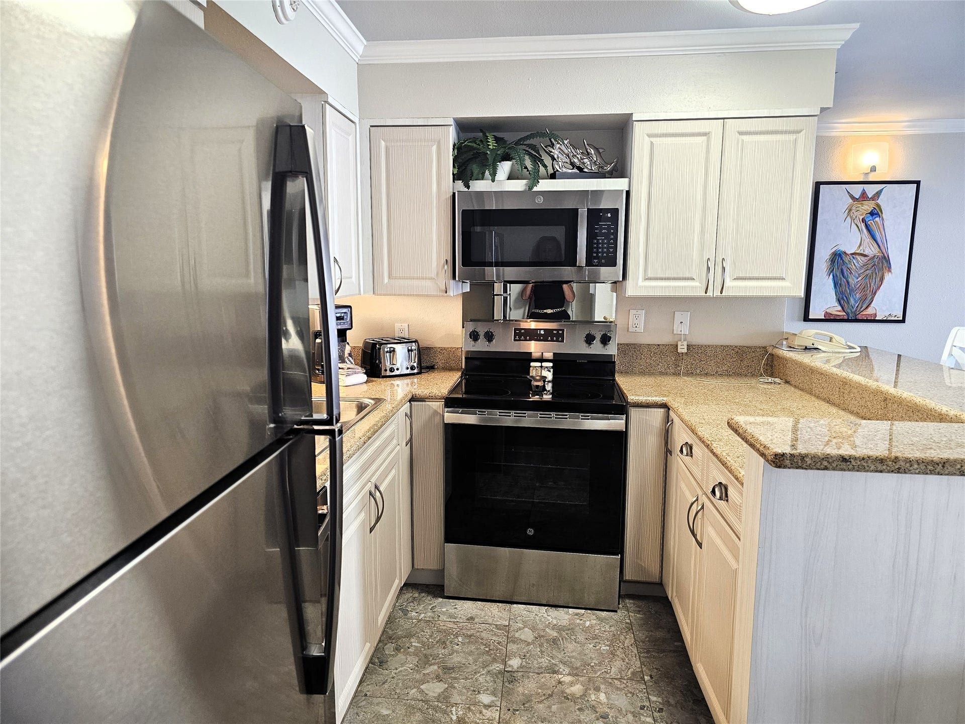 Modern kitchen with stainless steel appliances, sleek granite countertops, and ample cabinet space for storage.