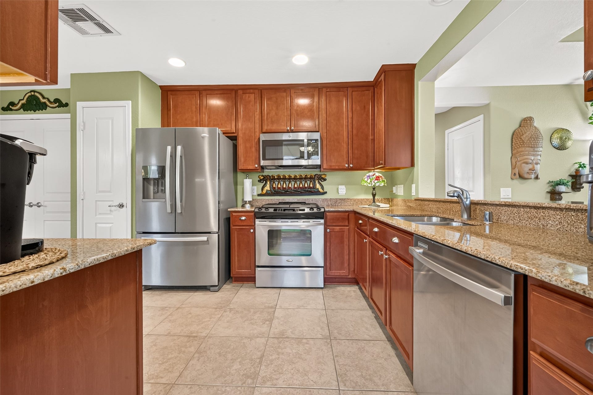 1126 Oleander Way, Richmond, TX 77469 Warm cabinetry, granite counters, and stainless appliances create an inviting kitchen.