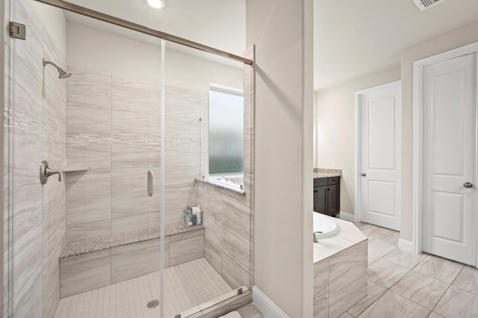Large walk in shower behind the soaking tub.