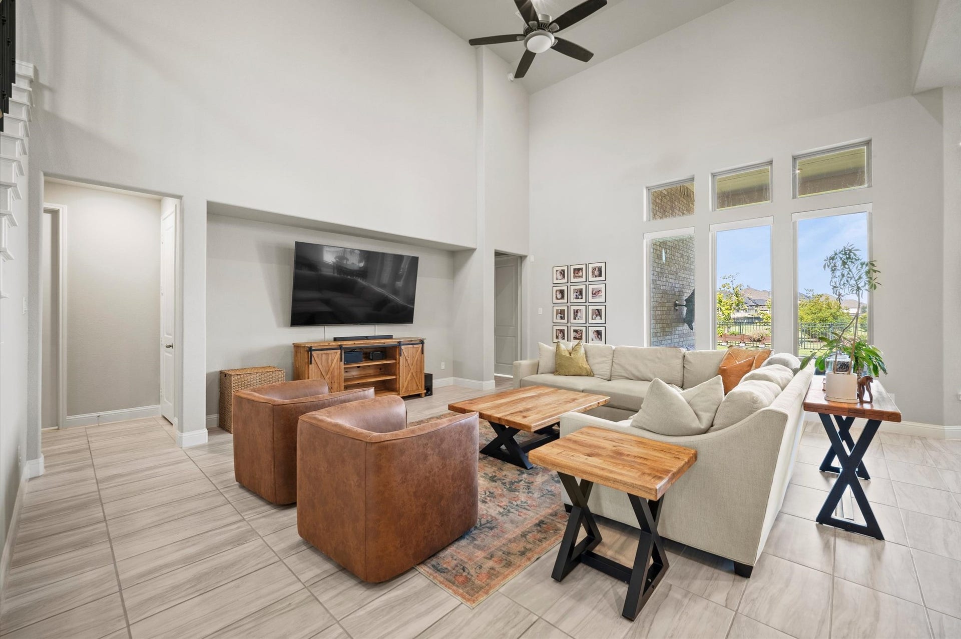 Spacious living room with high ceilings, complemented by large windows that offer smart shades with the push of a button!
