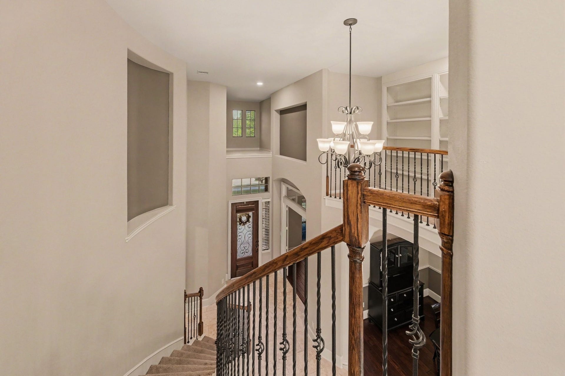 6410 Archer Ranch Lane, Rosenberg, TX 77471 Grand two-story entry featuring a sweeping curved staircase, elegant wrought-iron railings, and soaring ceilings.