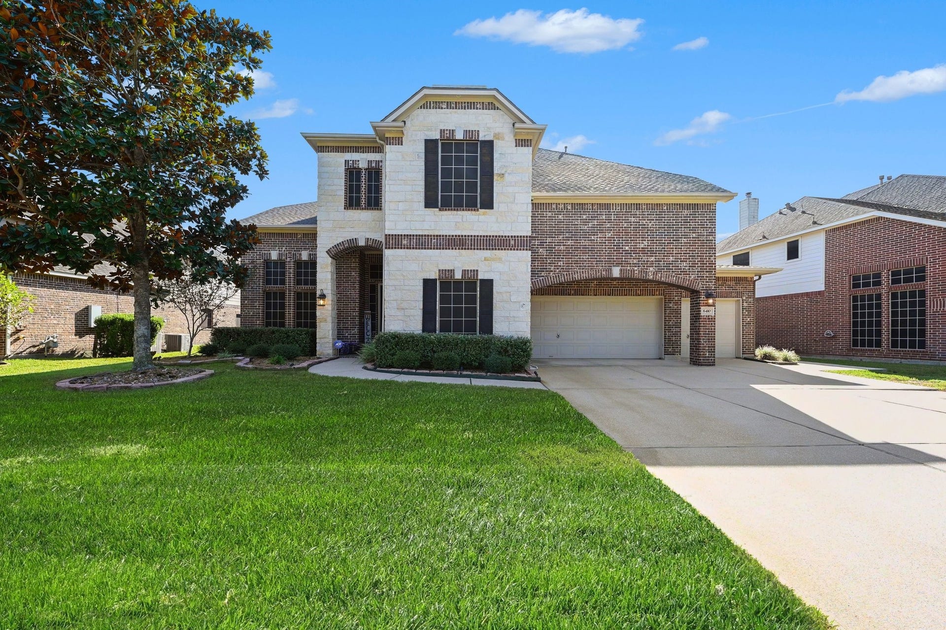 6410 Archer Ranch Lane, Rosenberg, TX 77471 Impressive two-story home with beautiful brick and stone accents, a three-car garage, and an expansive driveway.