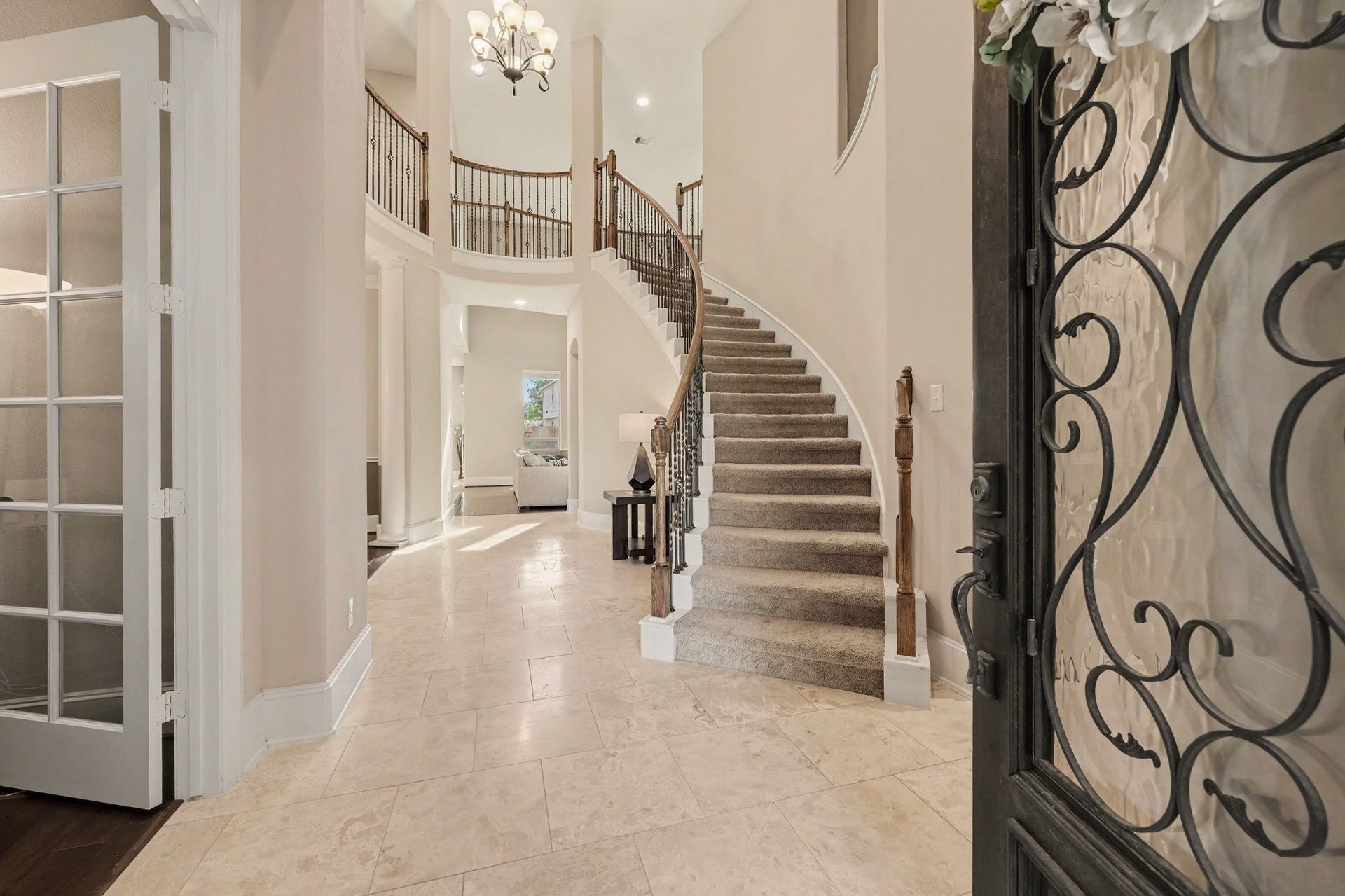 6410 Archer Ranch Lane, Rosenberg, TX 77471 Grand two-story entry featuring a sweeping curved staircase, elegant wrought-iron railings, and soaring ceilings.