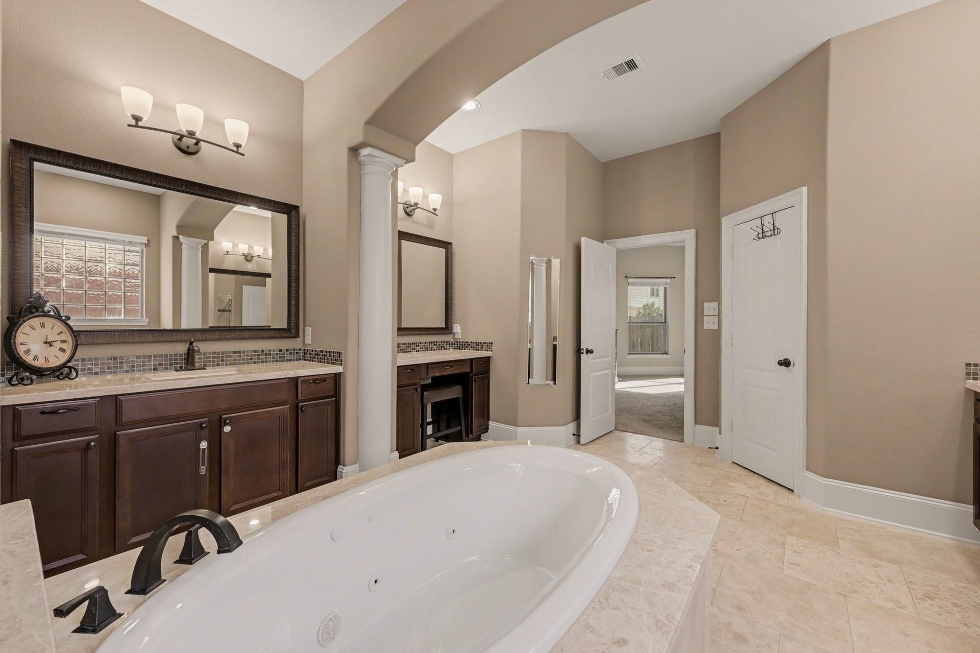 6410 Archer Ranch Lane, Rosenberg, TX 77471 Another view of the primary bathroom, highlighting the elegant architectural details, generous vanity space, and access to two separate walk-in closets.