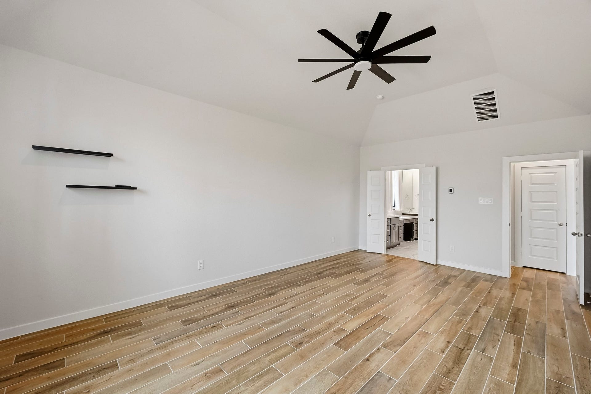 6718 Waxbill Road, Katy, TX 77493 Come relax in the primary retreat with a modern ceiling fan, wood-tile flooring, neutral paint, and direct access to your ensuite primary bathroom!