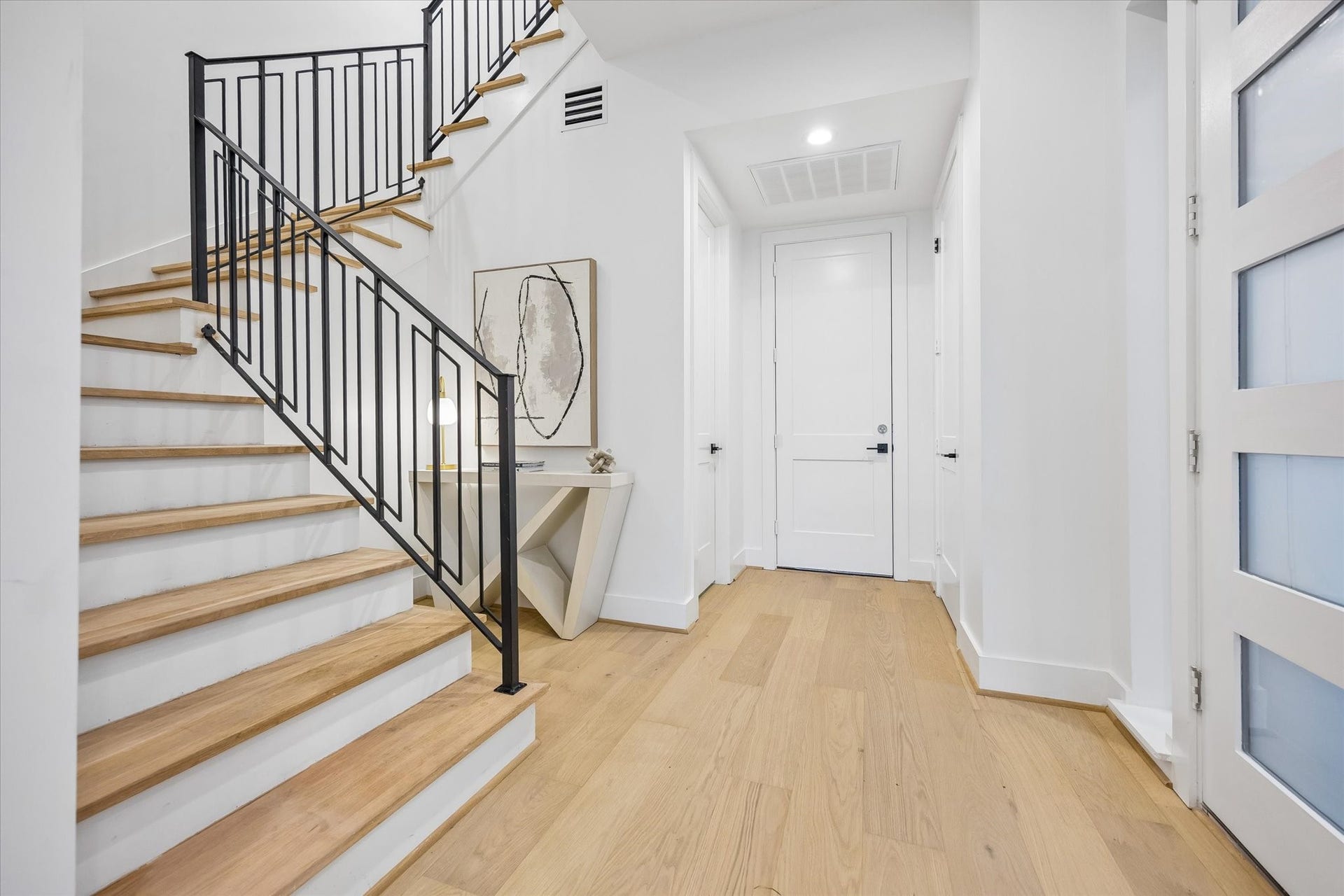 2204 Huldy Street, Houston, TX 77019 Another look at the beautiful entry highlighting the decorative staircase w/ modern black metal railing. Elevator-capable closet (to the right) are thoughtfully positioned on all 3 floors for future elevator installation. Entry provides convenient access to the powder bath (on the left), attached garage (straight ahead) & open-concept living areas.