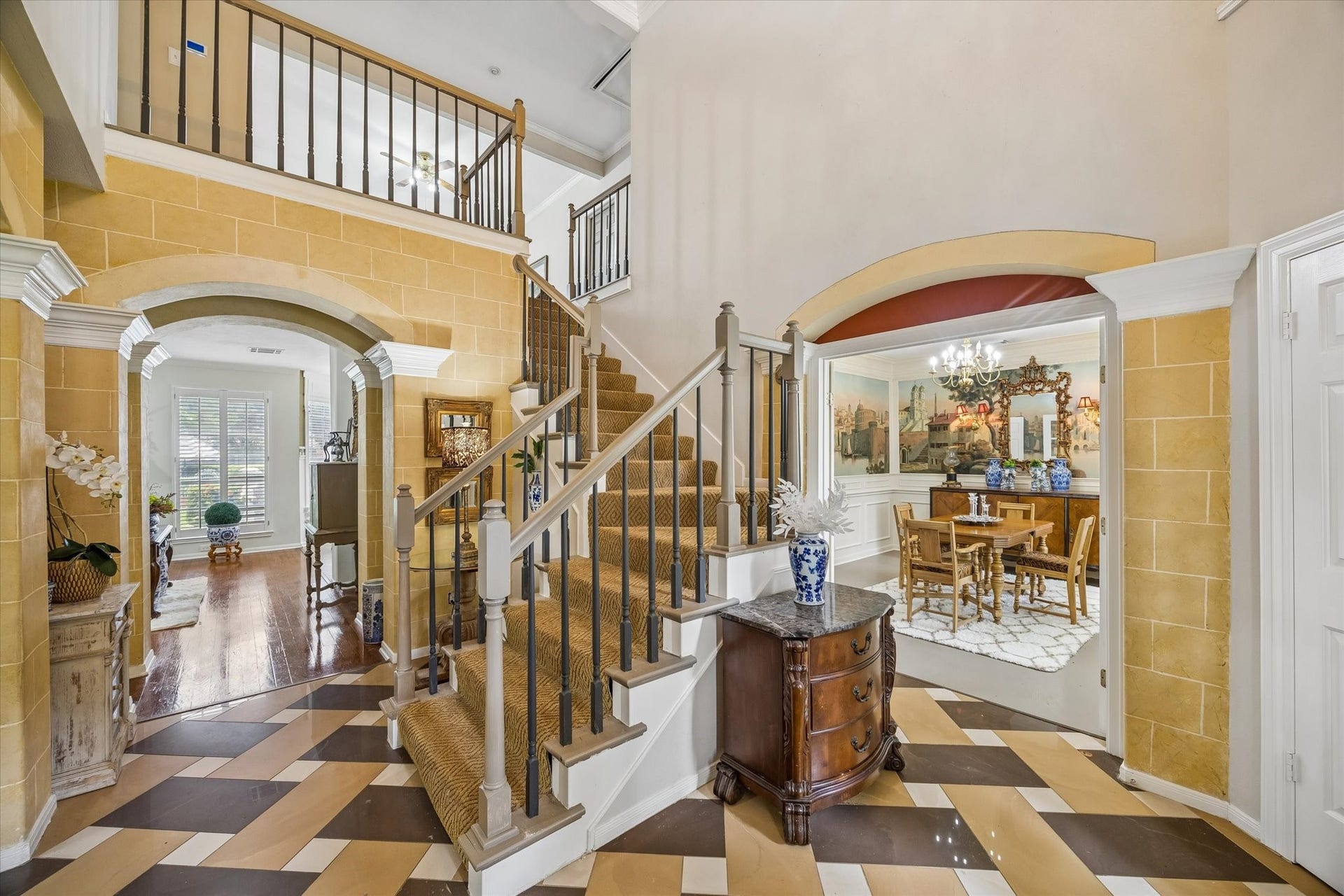 1019 Quiet Glen Court, Sugar Land, TX 77479 Grand entryway with a striking staircase, elegant tile flooring, and leading to a formal dining room and a light-filled living space.