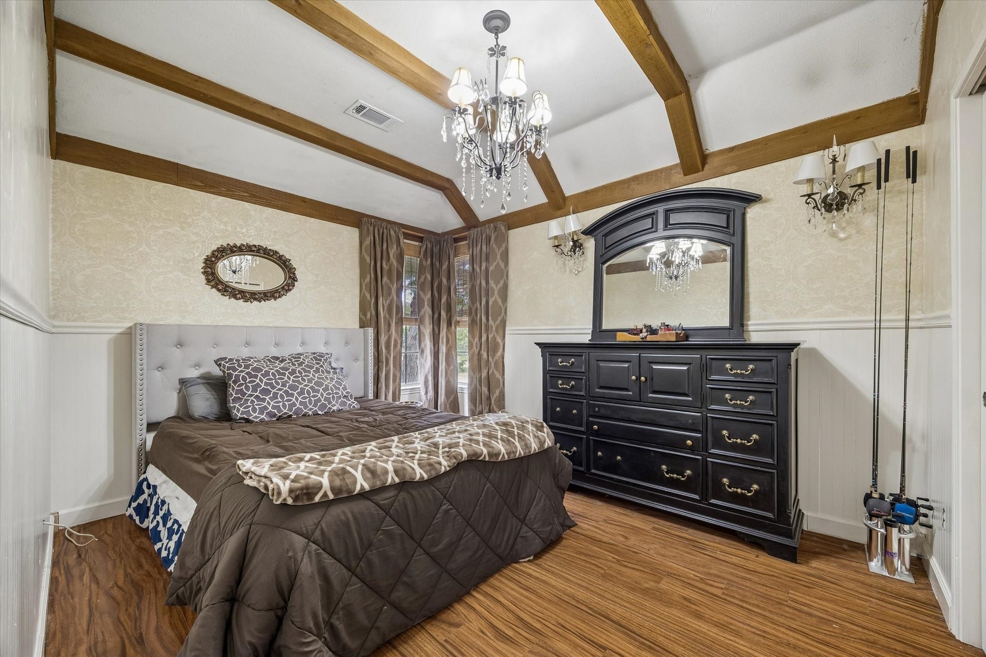 1019 Quiet Glen Court, Sugar Land, TX 77479 Charming bedroom featuring exposed wooden beams, a stylish chandelier, and elegant wainscoting.