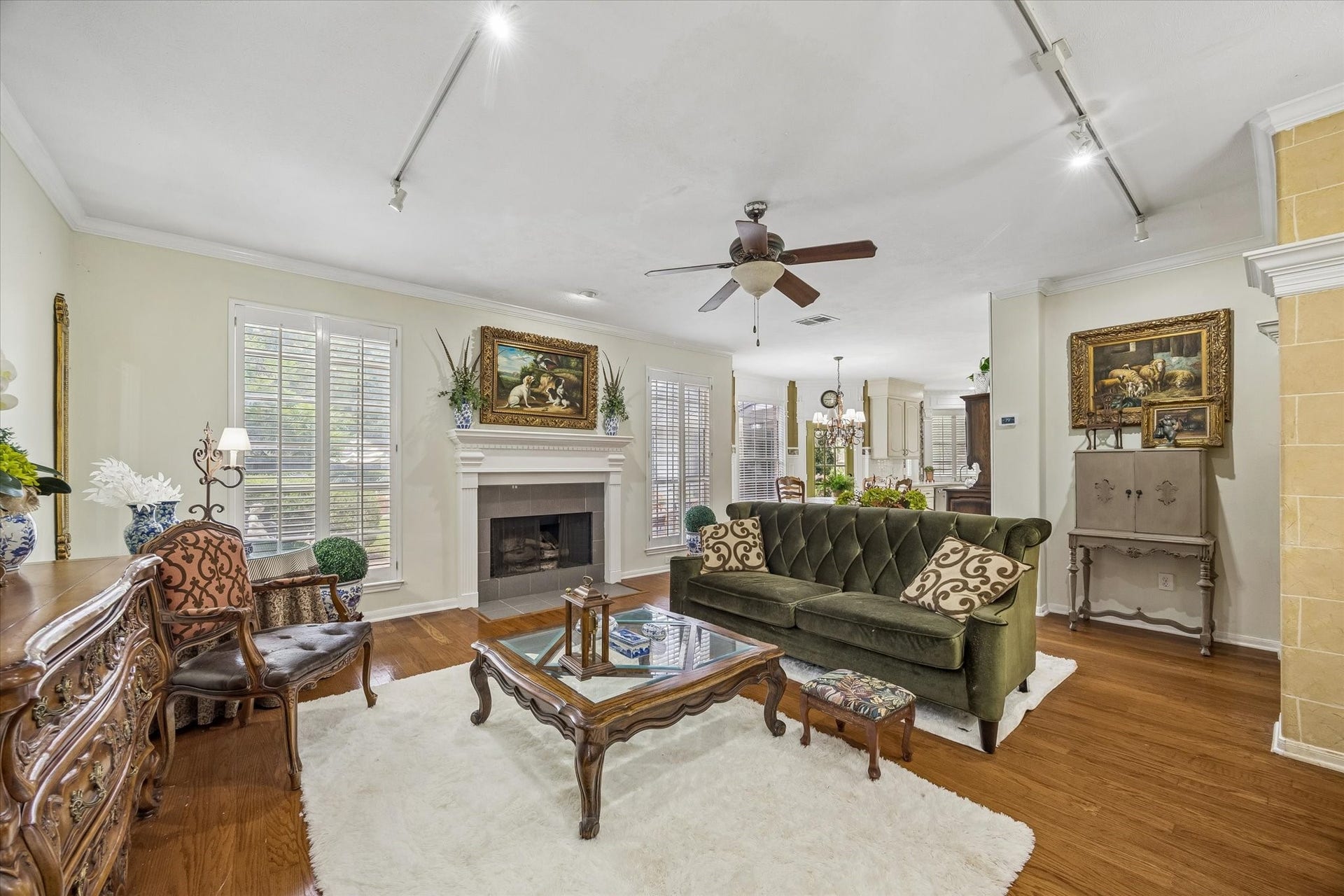 1019 Quiet Glen Court, Sugar Land, TX 77479 Living room featuring a cozy fireplace, rich wood flooring, and abundant natural light.