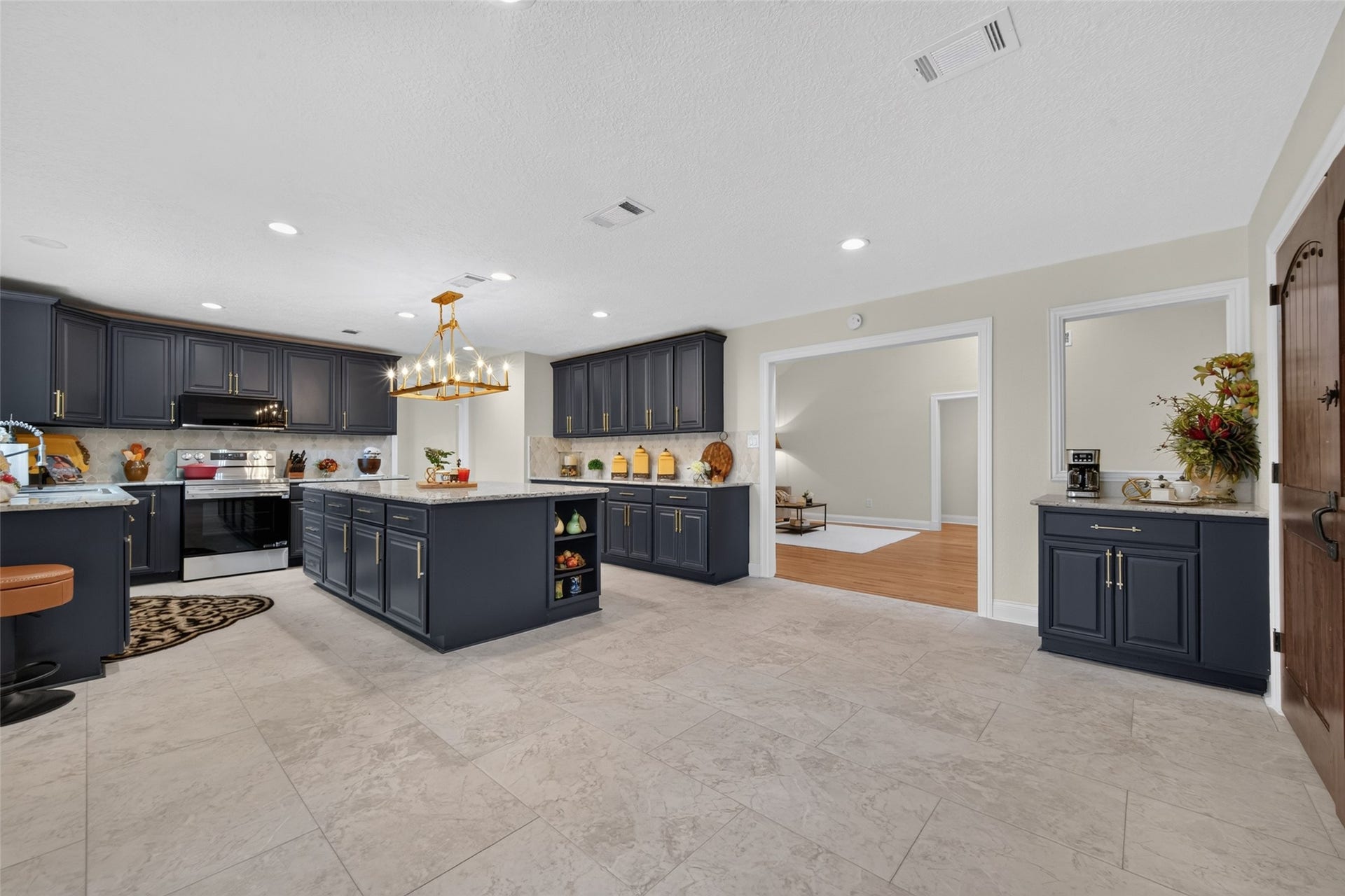 8906 Seber Drive, Tomball, TX 77375 Another view highlights the impressive size and versatility of the kitchen, with abundant workspace, casual island seating and plenty of room for a substantial dining table. A separate coffee nook provides additional cabinetry and counter space in a convenient location thats easily accessible from the kitchen and adjoining living areasperfect for a coffee or beverage station guests can enjoy without interrupting the cook.