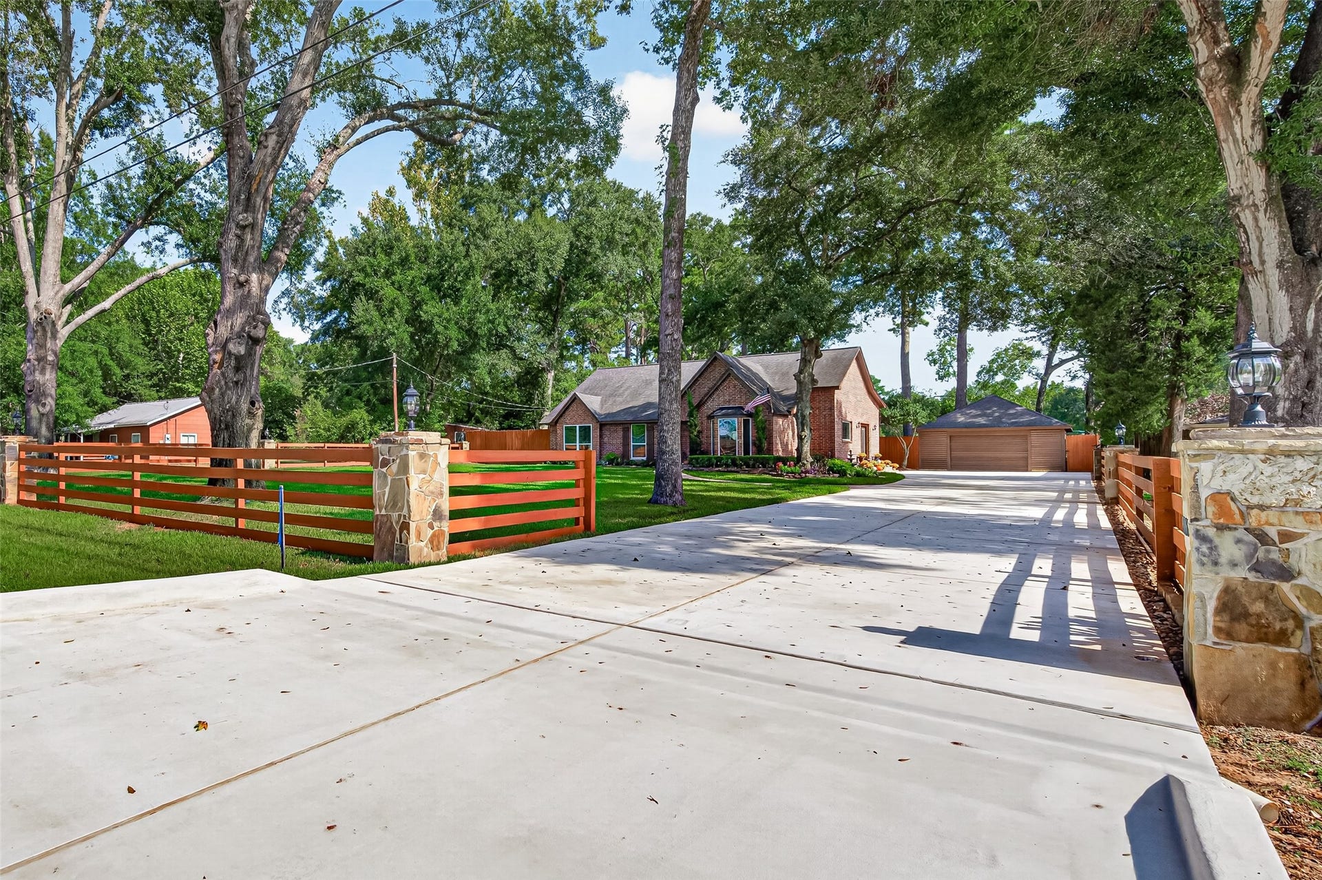 8906 Seber Drive, Tomball, TX 77375 Come on in! The long driveway leads you past the spacious front yard toward the home and detached garage, offering plenty of room for parking and easy access.