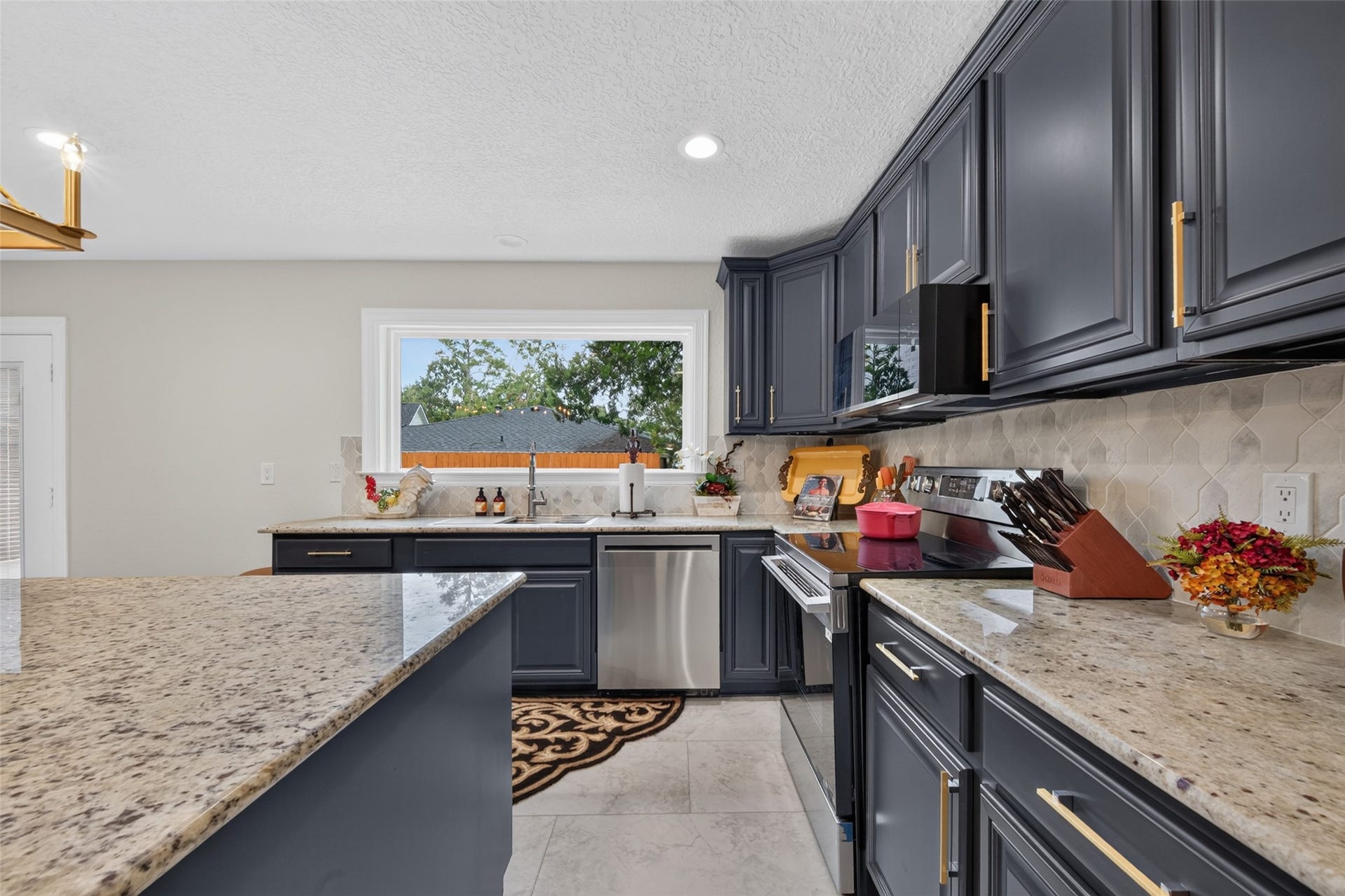 8906 Seber Drive, Tomball, TX 77375 Granite countertops, stainless appliances and a large window bring function and natural light.