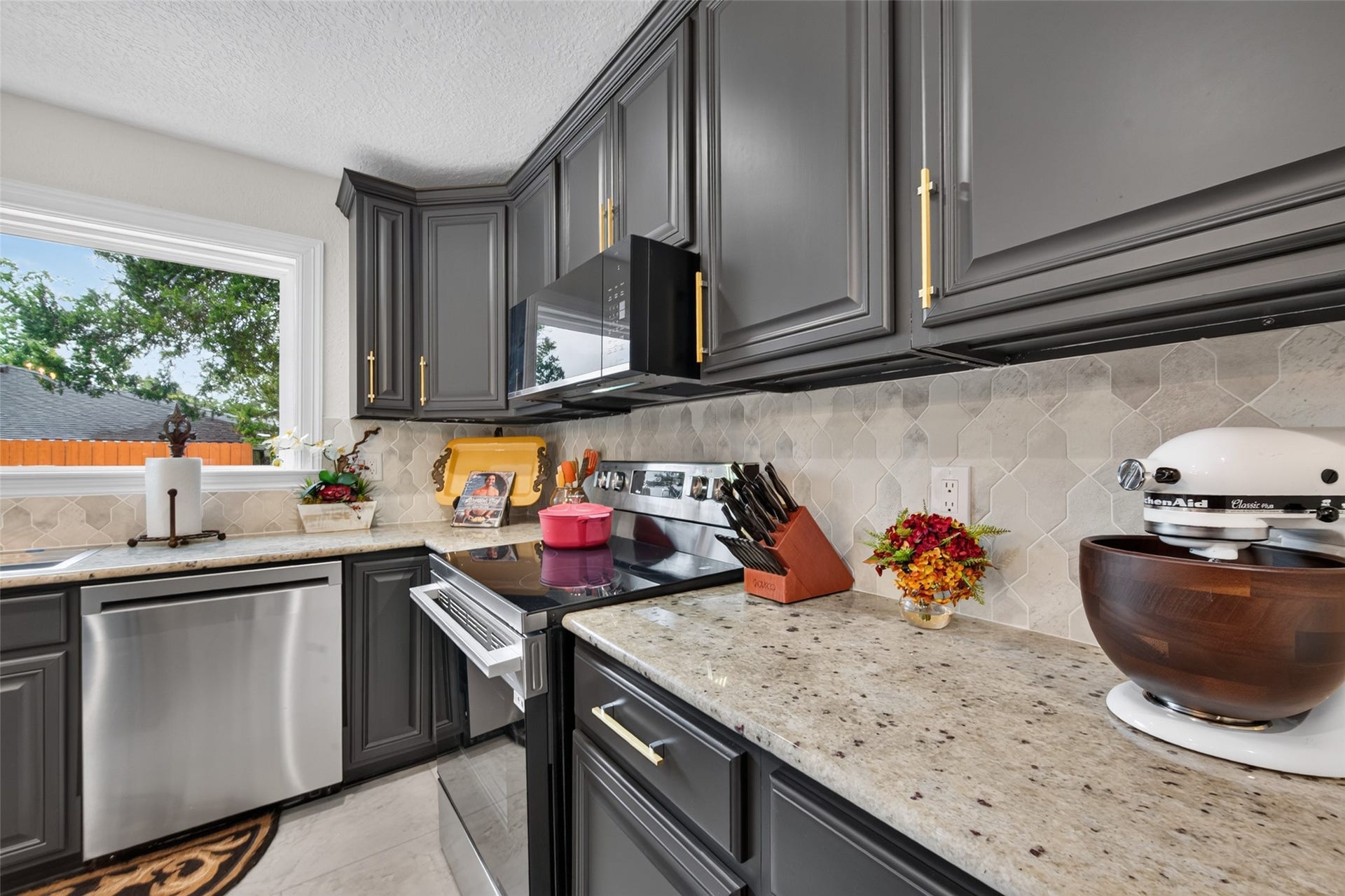 8906 Seber Drive, Tomball, TX 77375 Rich cabinetry, updated hardware and a beautiful tile backsplash complete the kitchen.