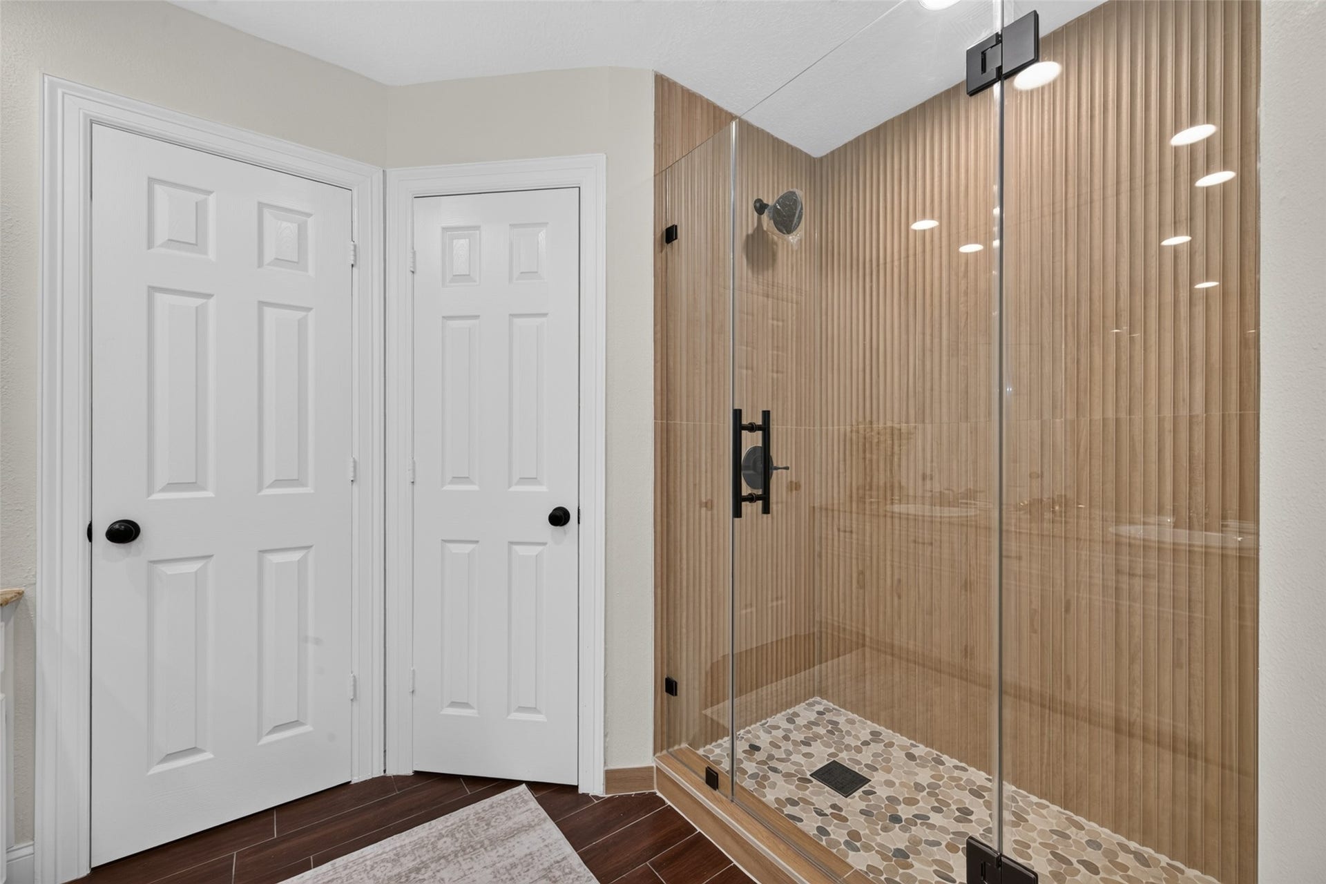 8906 Seber Drive, Tomball, TX 77375 Updated walk-in shower features frameless glass, modern black fixtures and a stylish textured tile surround.
