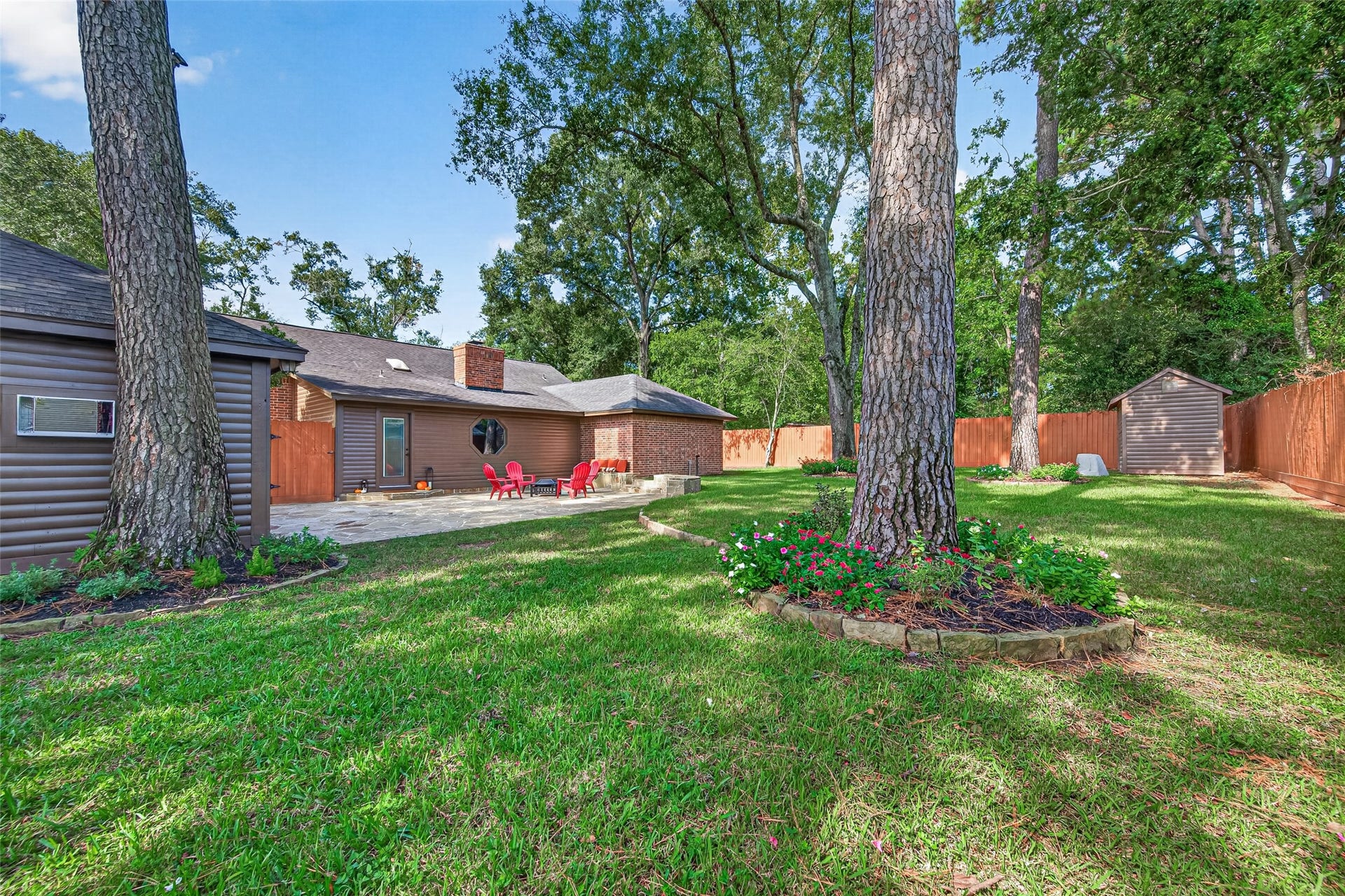 8906 Seber Drive, Tomball, TX 77375 Another view shows just how spacious this fully fenced backyard really is, complete with mature shade trees, established landscaping and a storage building.