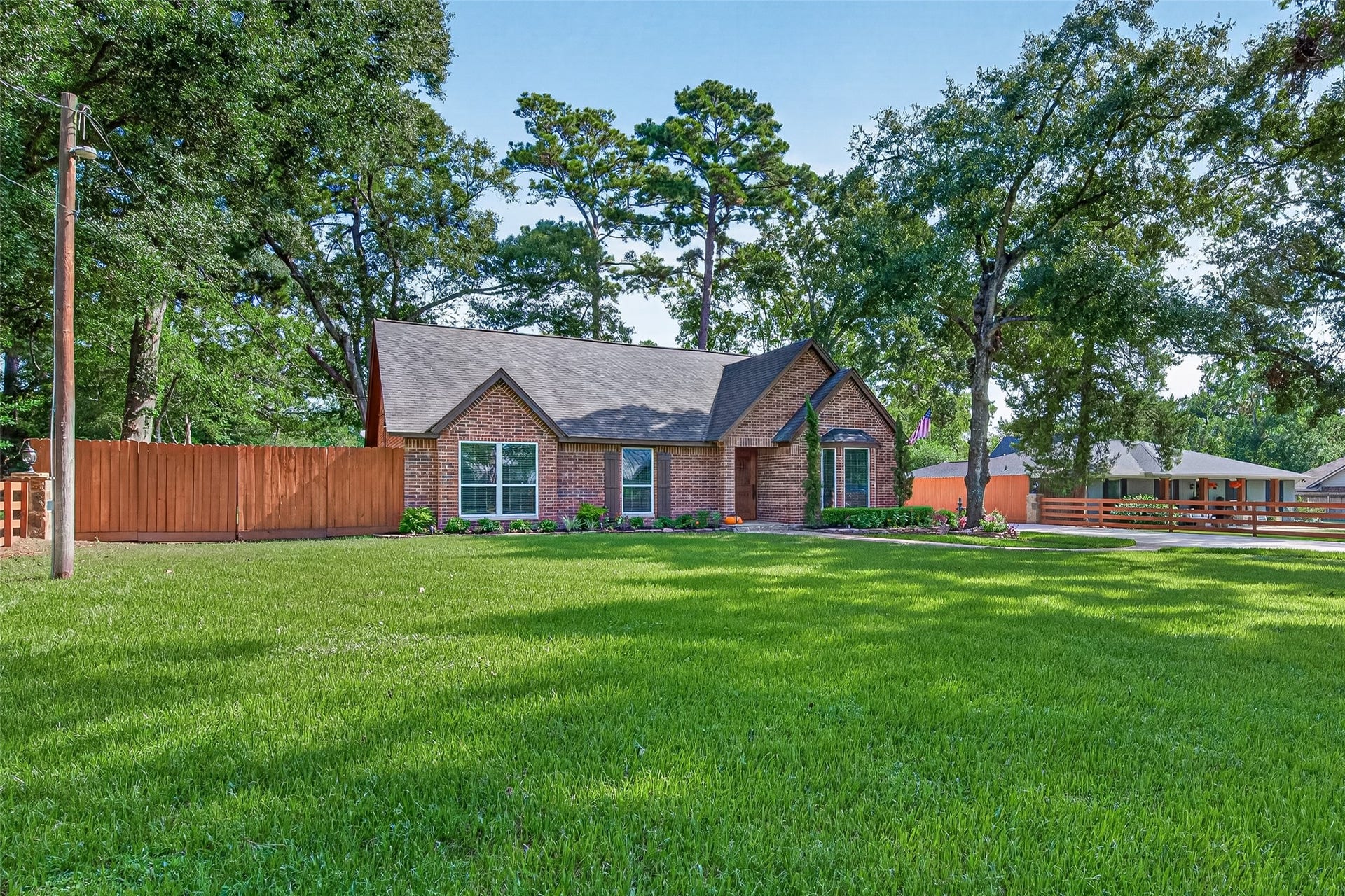 8906 Seber Drive, Tomball, TX 77375 A closer look at the front of the home showcases the brick exterior, mature trees, manicured lawn and colorful landscaping surrounding the entry.