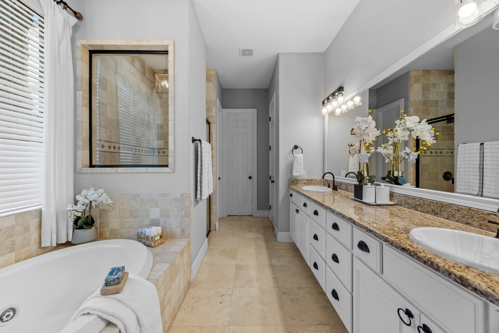 9238 Balsam Gap, Missouri City, TX 77459 The primary bathroom features a long dual sink vanity with abundant storage, a jetted soaking tub, and a separate glass enclosed shower. Natural light and neutral tile finishes create a relaxing, spa inspired retreat.
