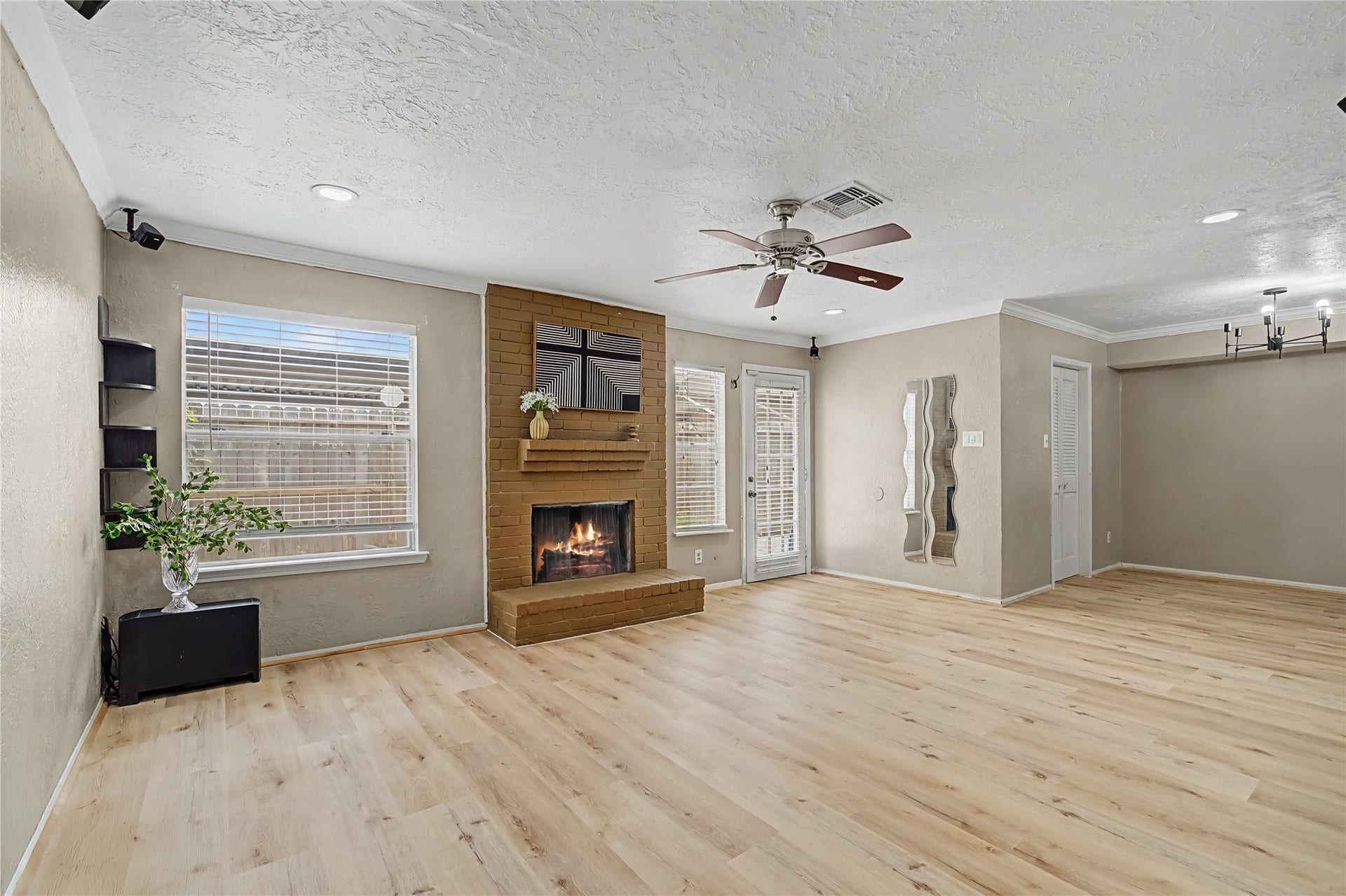 Another angle of the living area showcasing the fireplace, multiple windows, and direct access to the outdoor area.