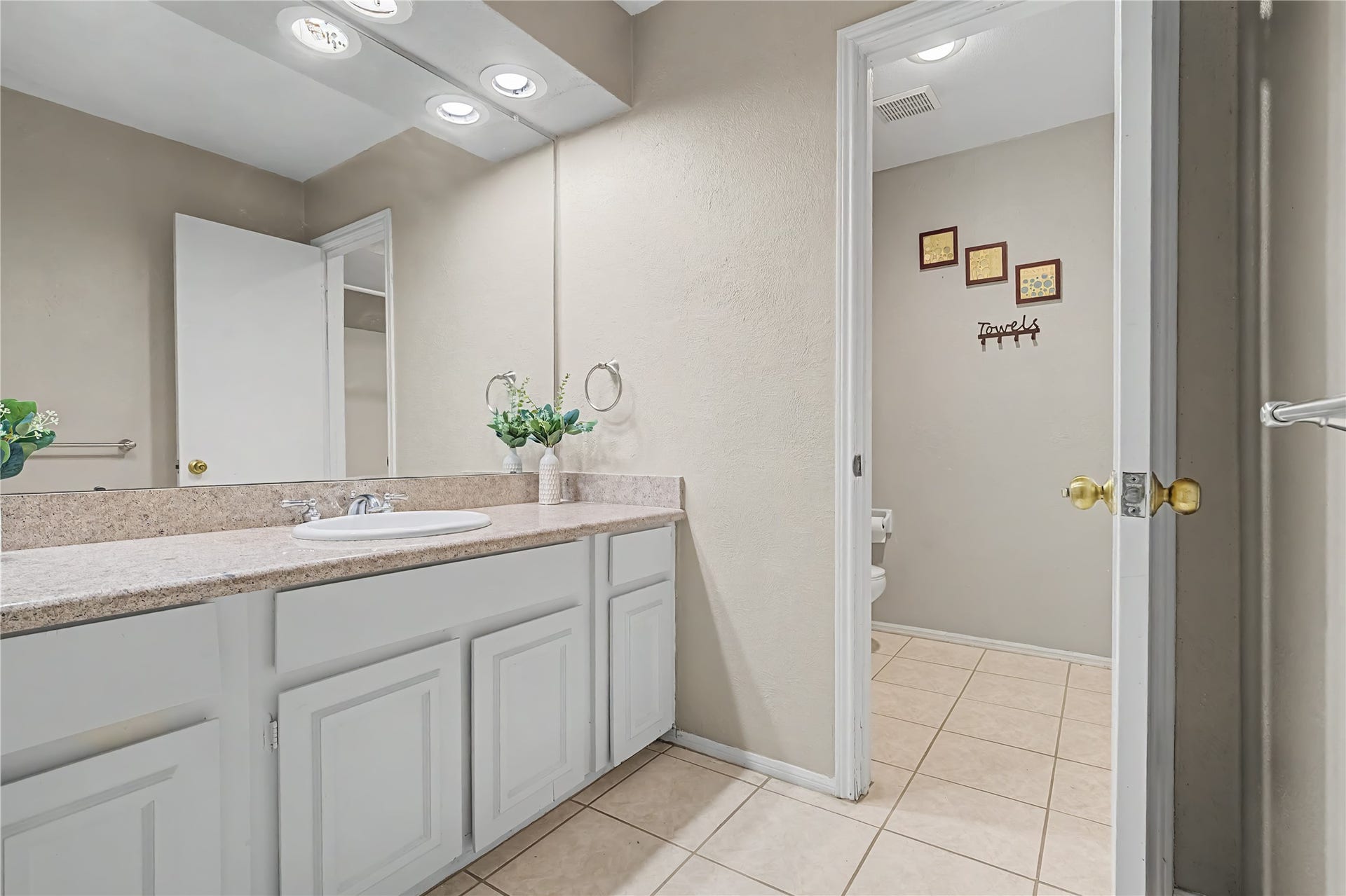 The secondary bathroom features a full bath with tub and shower combination with built-in shelving and tile flooring.