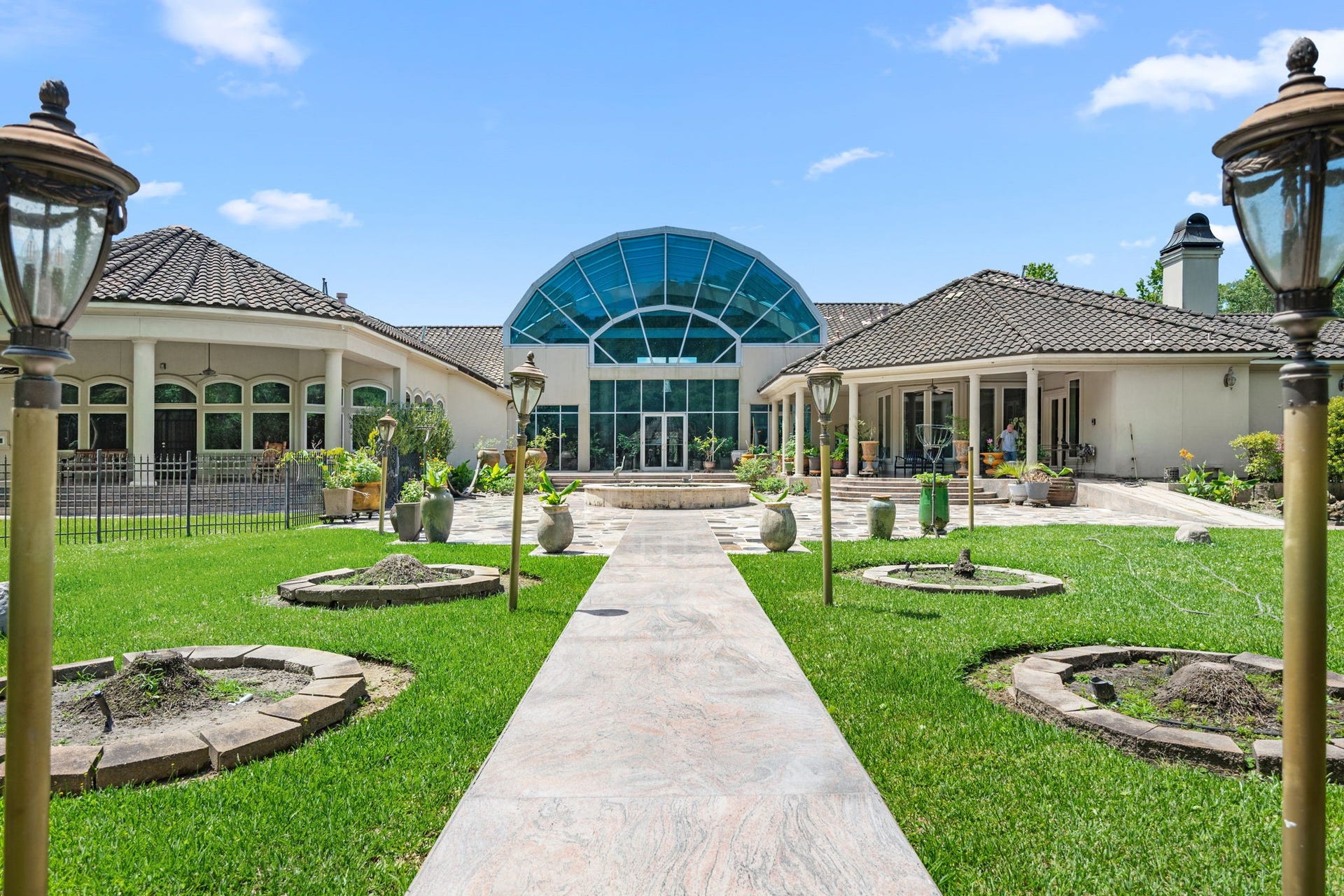 29310 Martelly Way, Huffman, TX 77336 Sophisticated and open rear view of home. Lush landscaping, and multiple outdoor living areas surround the dramatic glass atrium.
