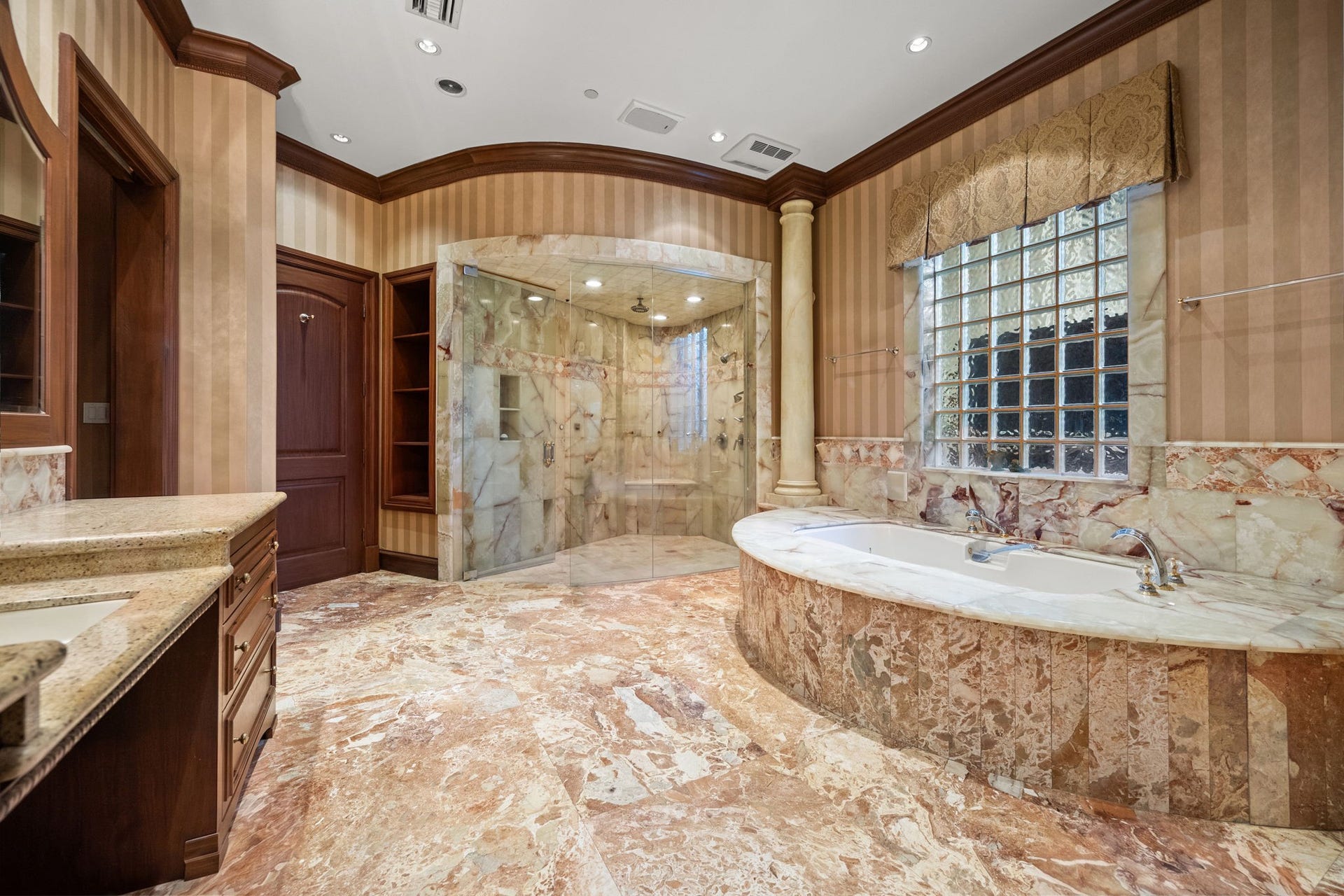 29310 Martelly Way, Huffman, TX 77336 Rich natural stone, elegant columns, and an oversized marble shower define the primary bath, creating a timeless retreat of sophistication and luxury.