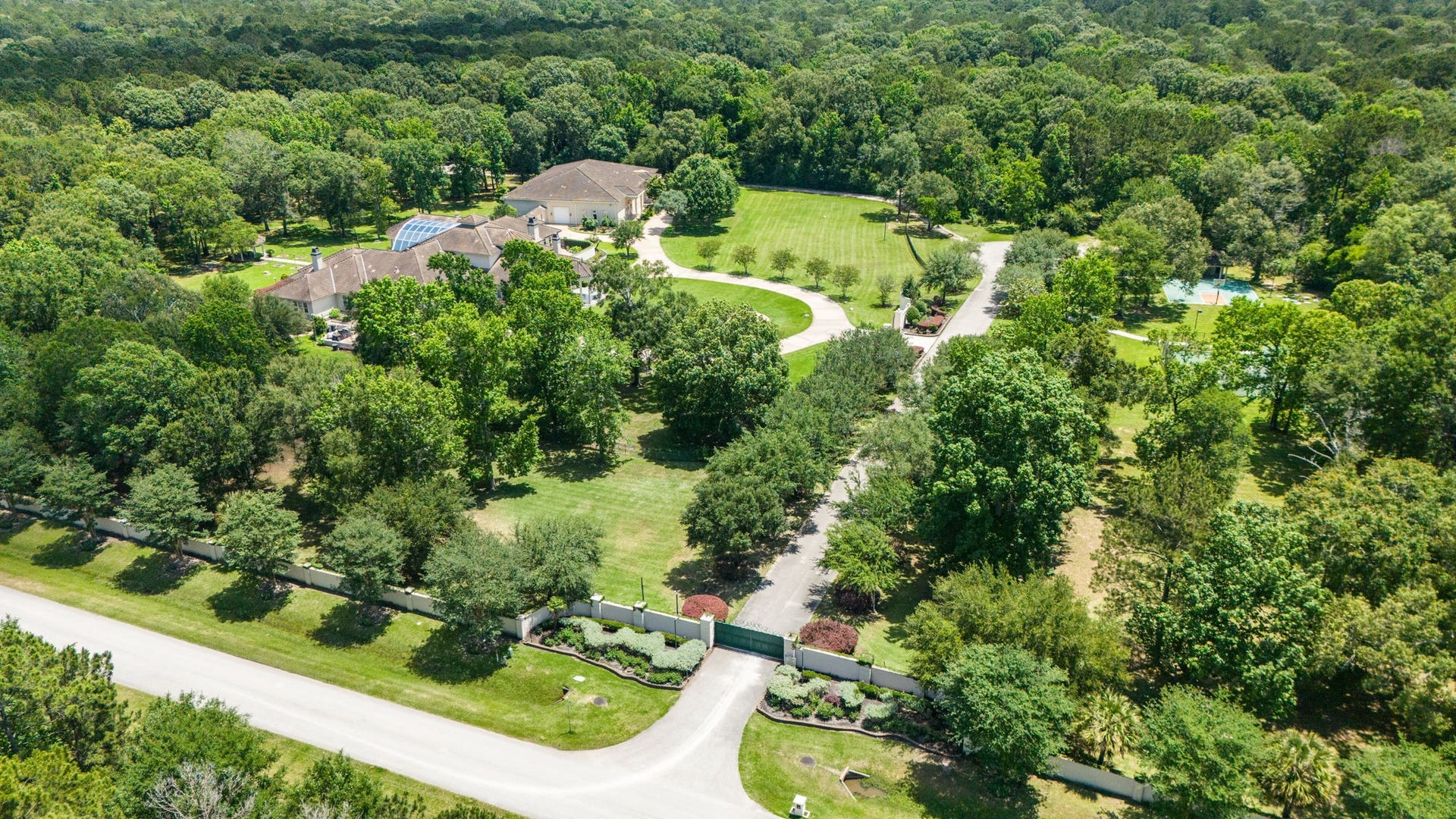 29310 Martelly Way, Huffman, TX 77336 Beyond the gated entrance, are pristine acres that unfold into a secluded retreat where manicured grounds, mature hardwoods, a private pond, tennis court, and resort-style amenities create an extraordinary estate unlike any other.