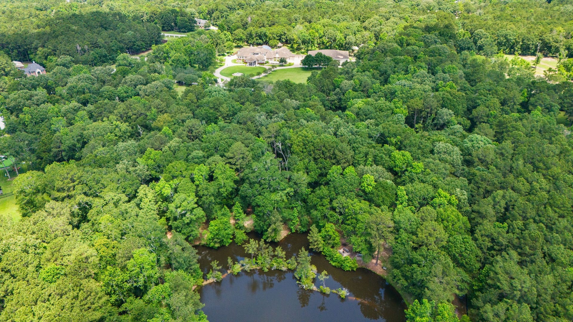 29310 Martelly Way, Huffman, TX 77336 The property's private pond and densely wooded acreage create a picturesque backdrop, offering peaceful water views and abundant wildlife.