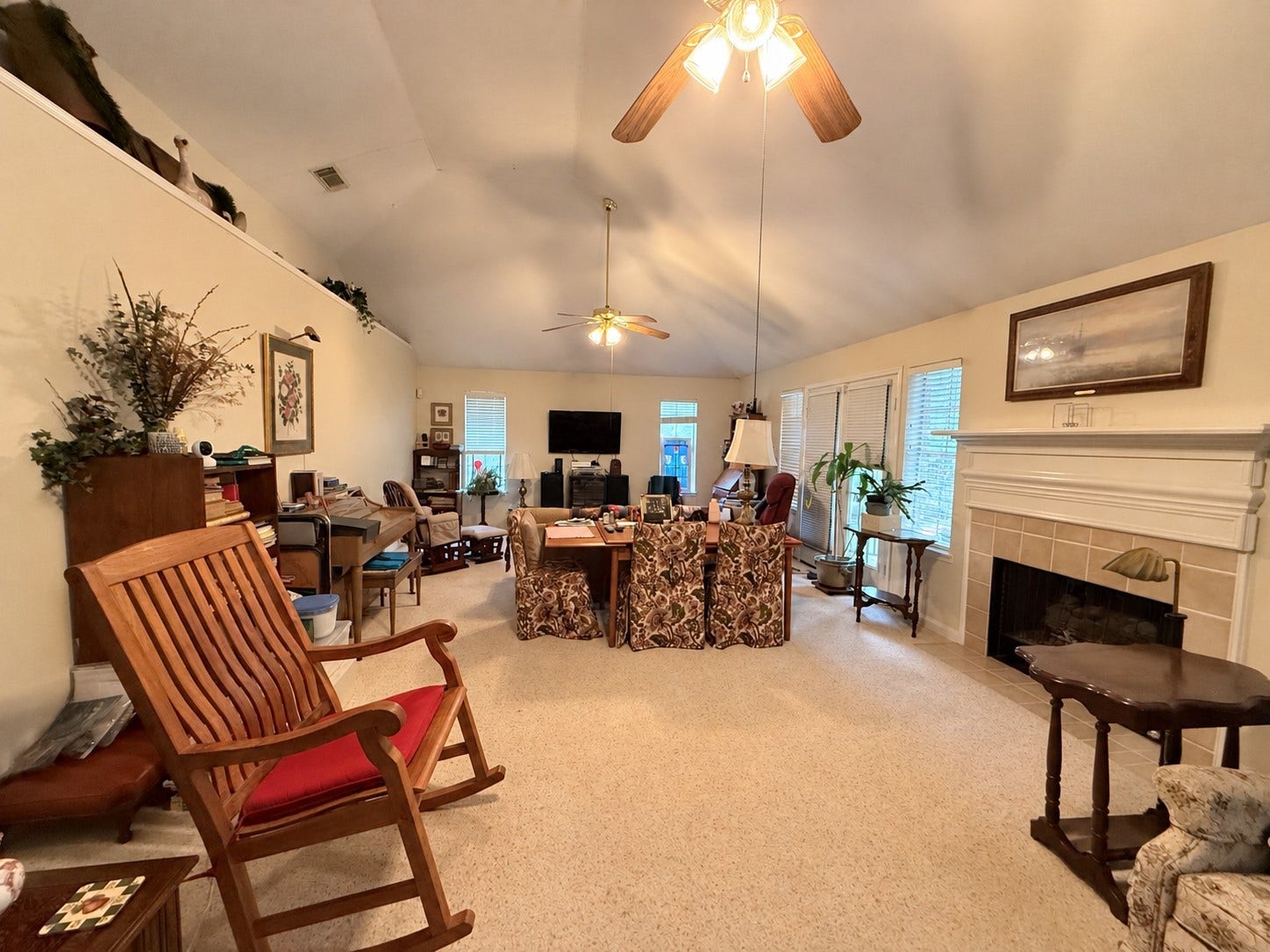 1600 Carriage Run W, Conroe, TX 77384 Room to Relax, Gather & Enjoy! This expansive family room offers endless possibilities with its soaring vaulted ceiling, tile-surround gas log fireplace with wood mantel, and two lighted ceiling fans. An abundance of windows fills the space with natural light, creating a bright and welcoming atmosphere. With so much room to work with, there's plenty of flexibility for multiple seating arrangements, entertaining, or simply spreading out and enjoying everyday living!
