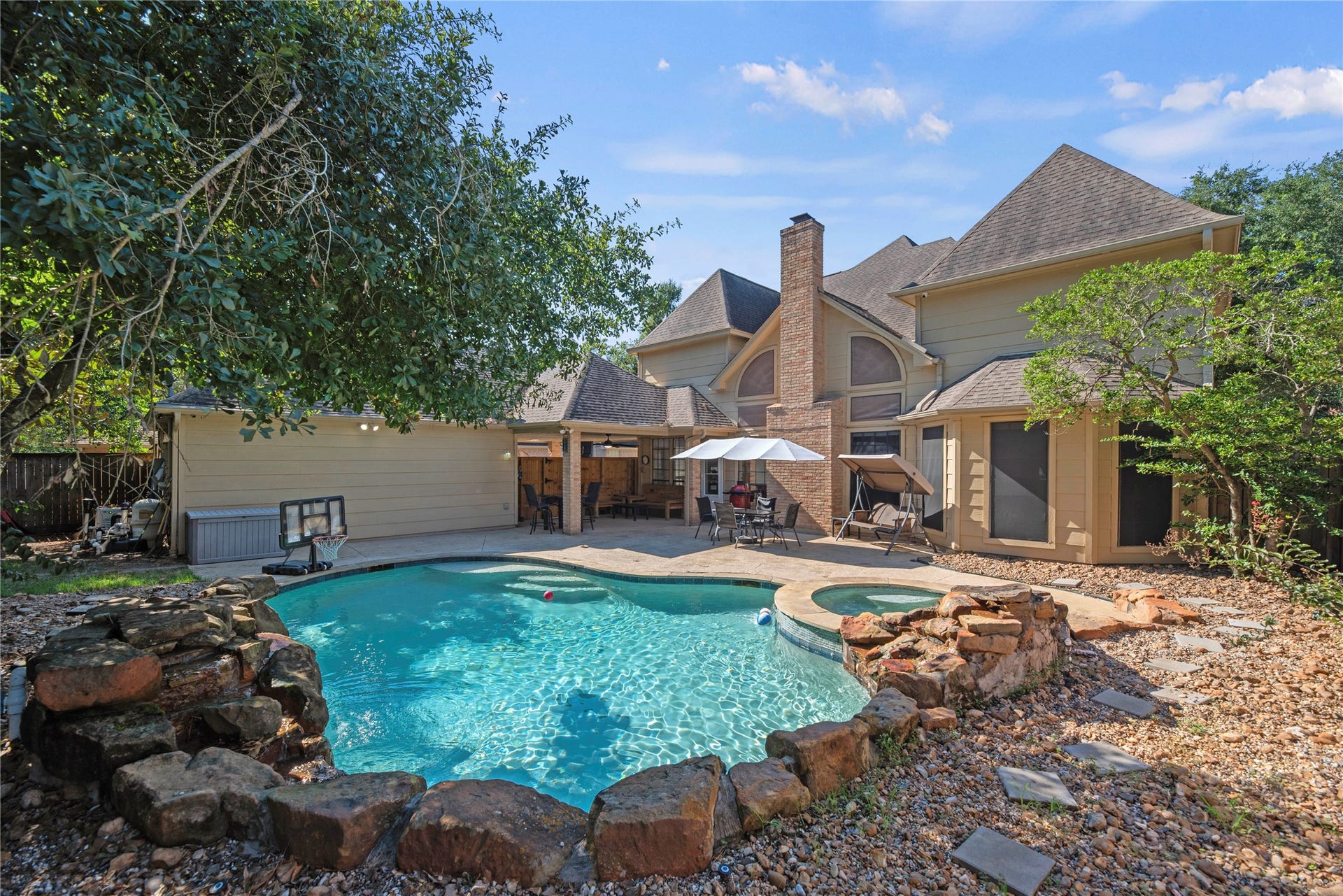 5823 Ashmere Lane, Spring, TX 77379 Why plan a weekend getaway when your backyard looks like this? The sparkling heated pool, spa and cascading waterfalls set the scene for fun, while the spacious covered patio offers a shady spot for outdoor dining and catching up with friends.
