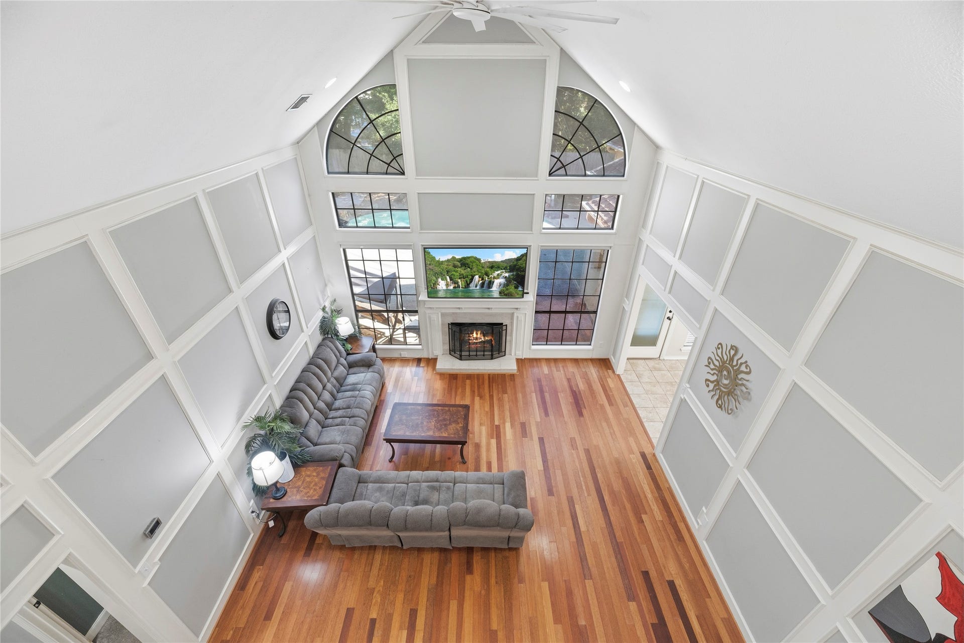 5823 Ashmere Lane, Spring, TX 77379 Just as impressive from above, this family room offers the perfect space for comfortable everyday living and epic entertaining. Soaring ceilings, dramatic windows and beautiful architectural details create an open, airy atmosphere, while rich hardwood floors and a cozy gas log fireplace bring warmth and character to this inviting space.