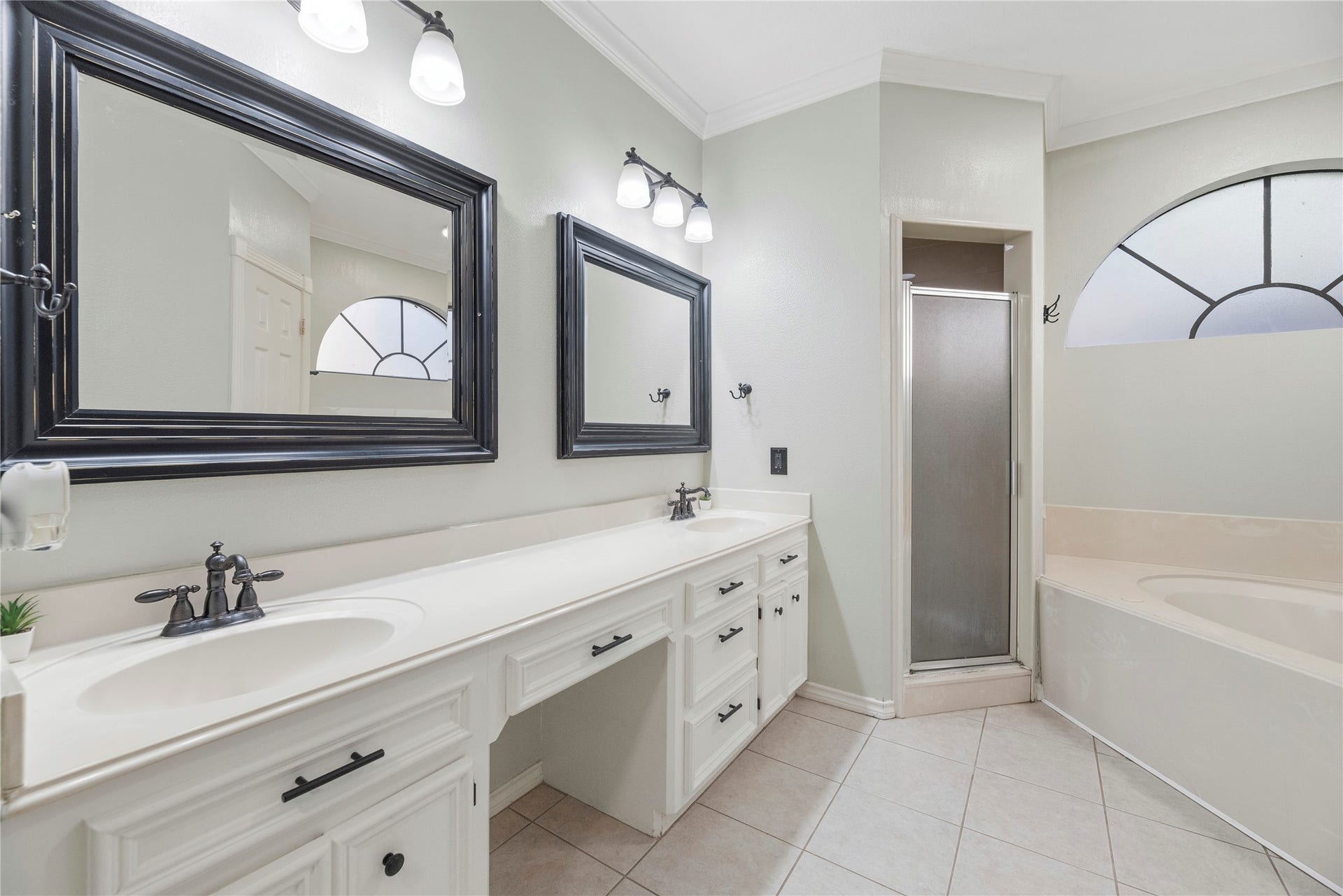 5823 Ashmere Lane, Spring, TX 77379 The spacious primary bath features a long dual-sink vanity with framed mirrors, stylish vanity lighting and plenty of cabinet storage. A dedicated knee space offers a comfortable spot to sit while and primp, while the deep soaking tub and separate walk-in shower provide options for relaxing or getting out the door.