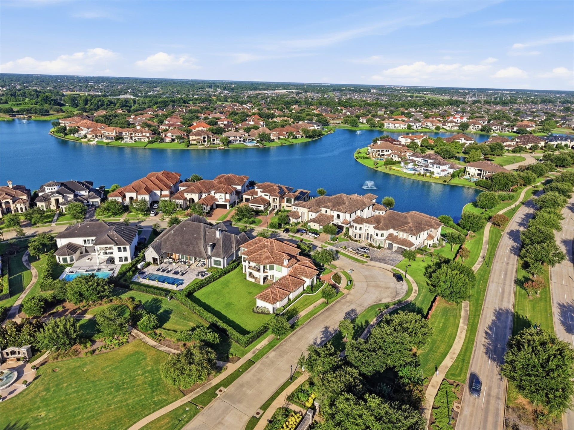 Elevated view displaying the community's waterfront setting, fountain features, and surrounding neighborhood design.