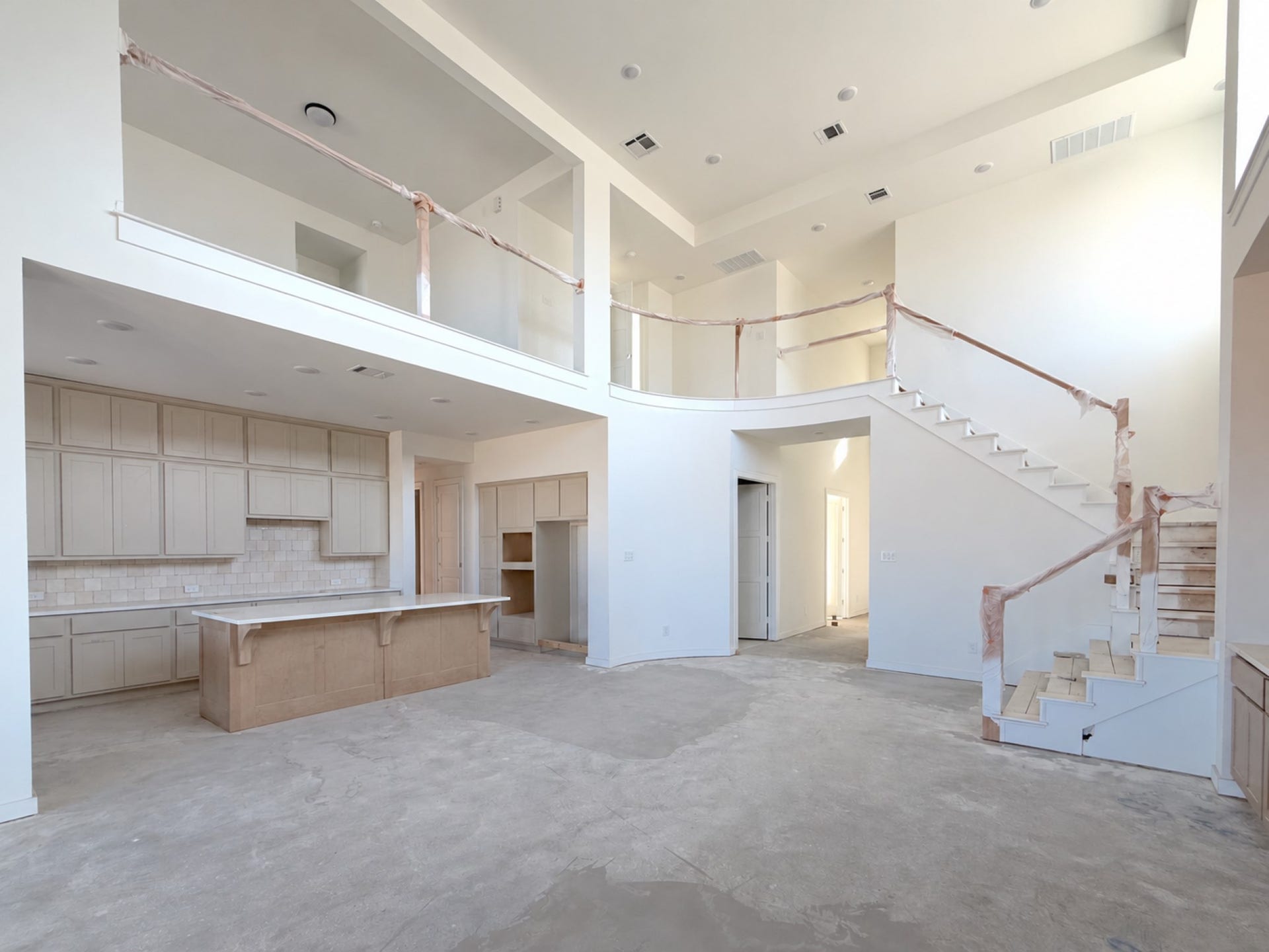 7819 Elizabeth Creek Court, Richmond, TX 77469 Expansive open concept living area featuring soaring ceilings, a dramatic staircase, and a curved open to below