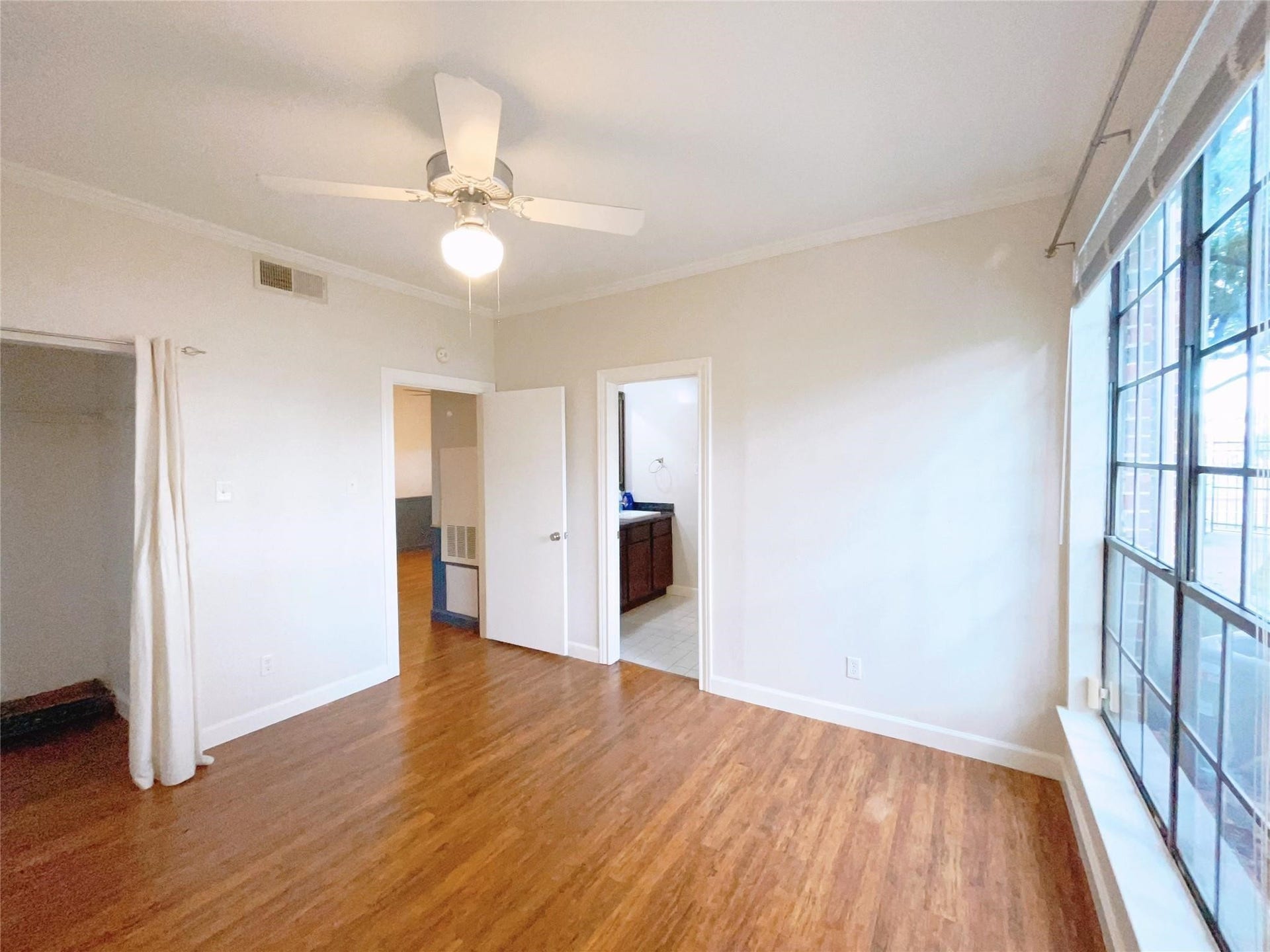 2121 El Paseo Street, #1511, Houston, TX 77054 Inviting bedroom featuring warm hardwood flooring, a ceiling fan, and a bright, comfortable layout.