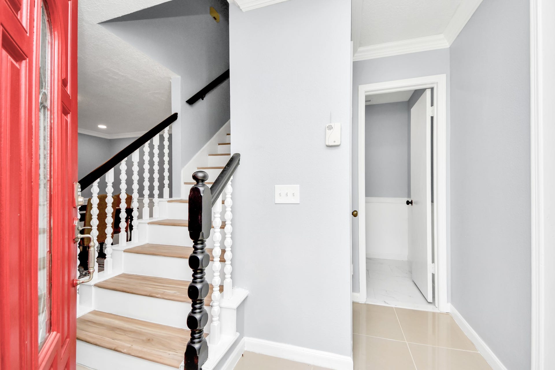 2903 Blue Glen Lane, Houston, TX 77073 The front door swings open to reveal a stylish, crisp interior where an elegant staircase featuring rich wood treads and contrasting white risers ascends gracefully to the upper level.