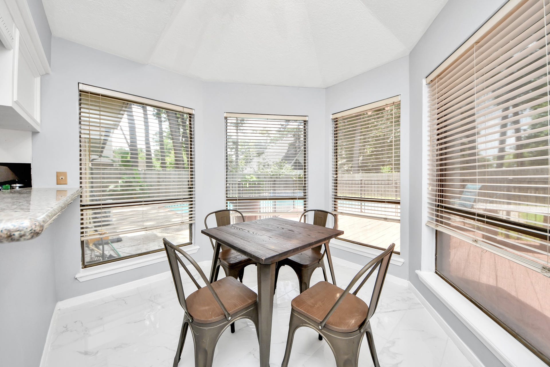2903 Blue Glen Lane, Houston, TX 77073 Sun-drenched morning perfection. Wrapped in a bank of oversized windows, this cheerful casual dining space offers panoramic, uninterrupted views of the sparkling pool area outside.