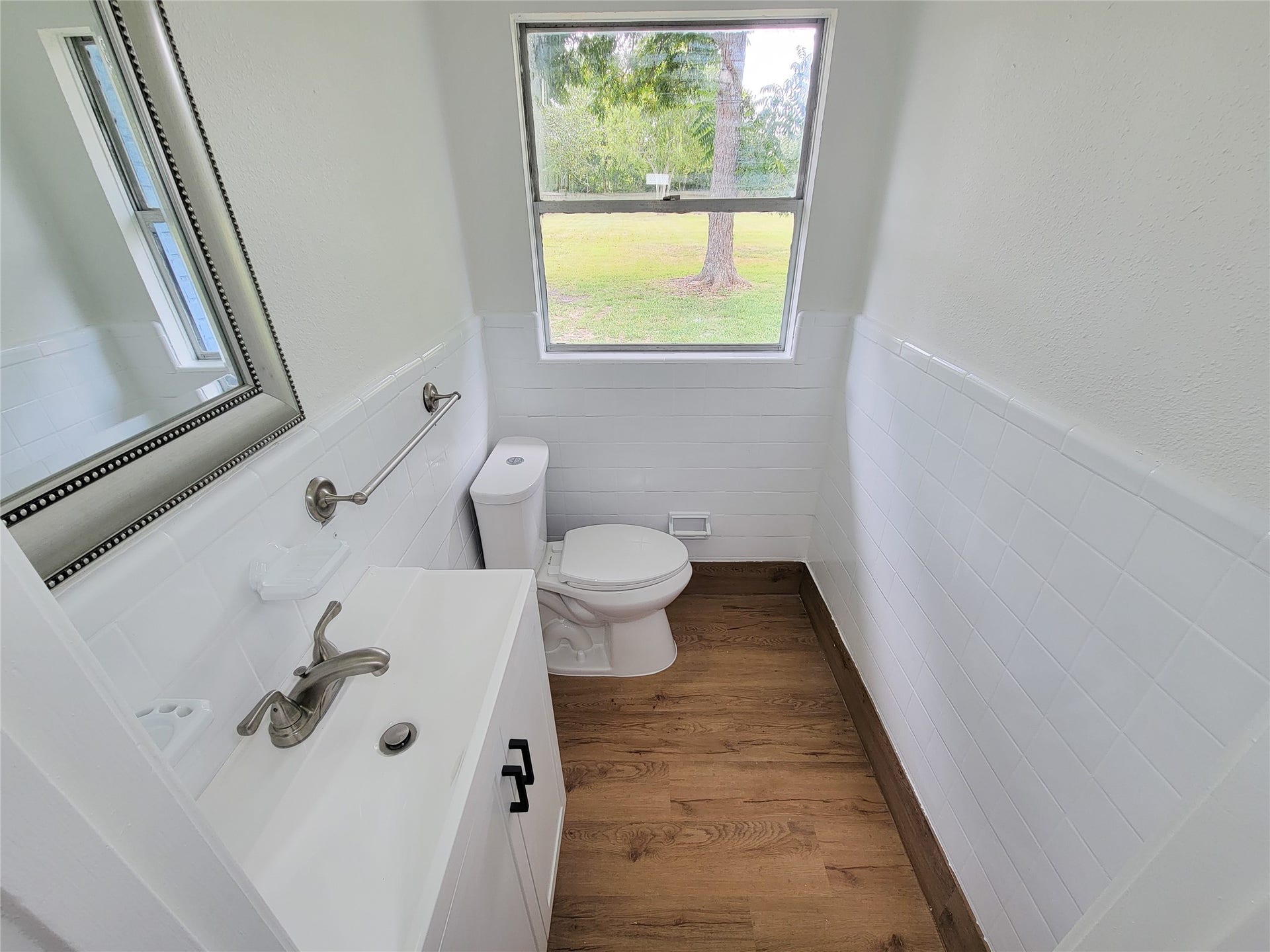 2605 W Dumble Street, Alvin, TX 77511 Charming bathroom with a modern vanity, sleek fixtures, and a bright window offering serene outdoor views.