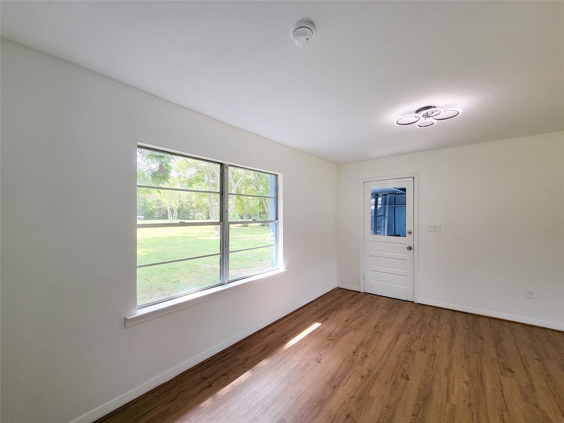 2605 W Dumble Street, Alvin, TX 77511 Discover a bright sanctuary with a large window showcasing scenic outdoor views, enhanced by sleek wood flooring and modern lighting.
